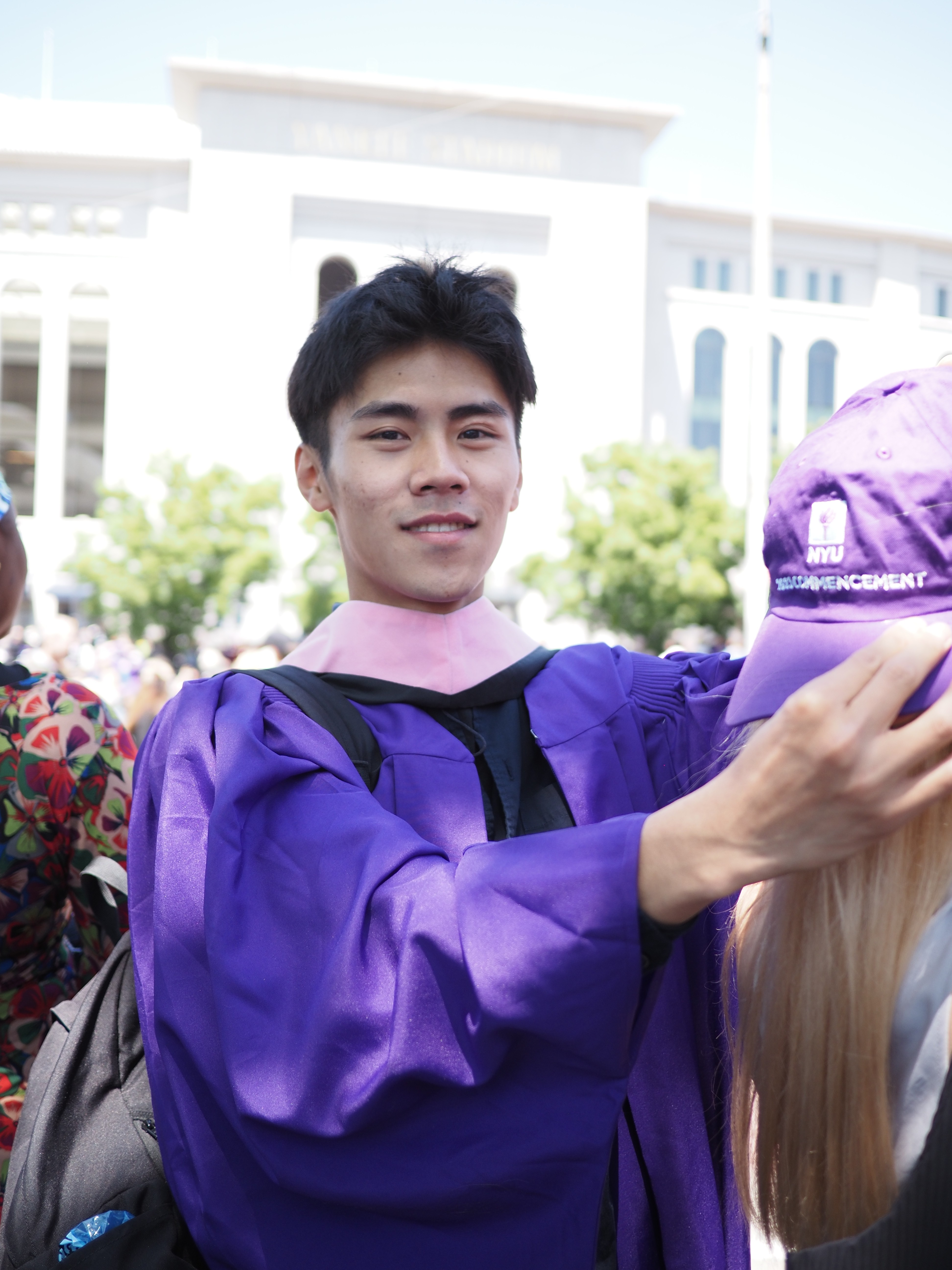 A thoughtful young person with dark hair gazes to the side, captured in soft black and white lighting.
