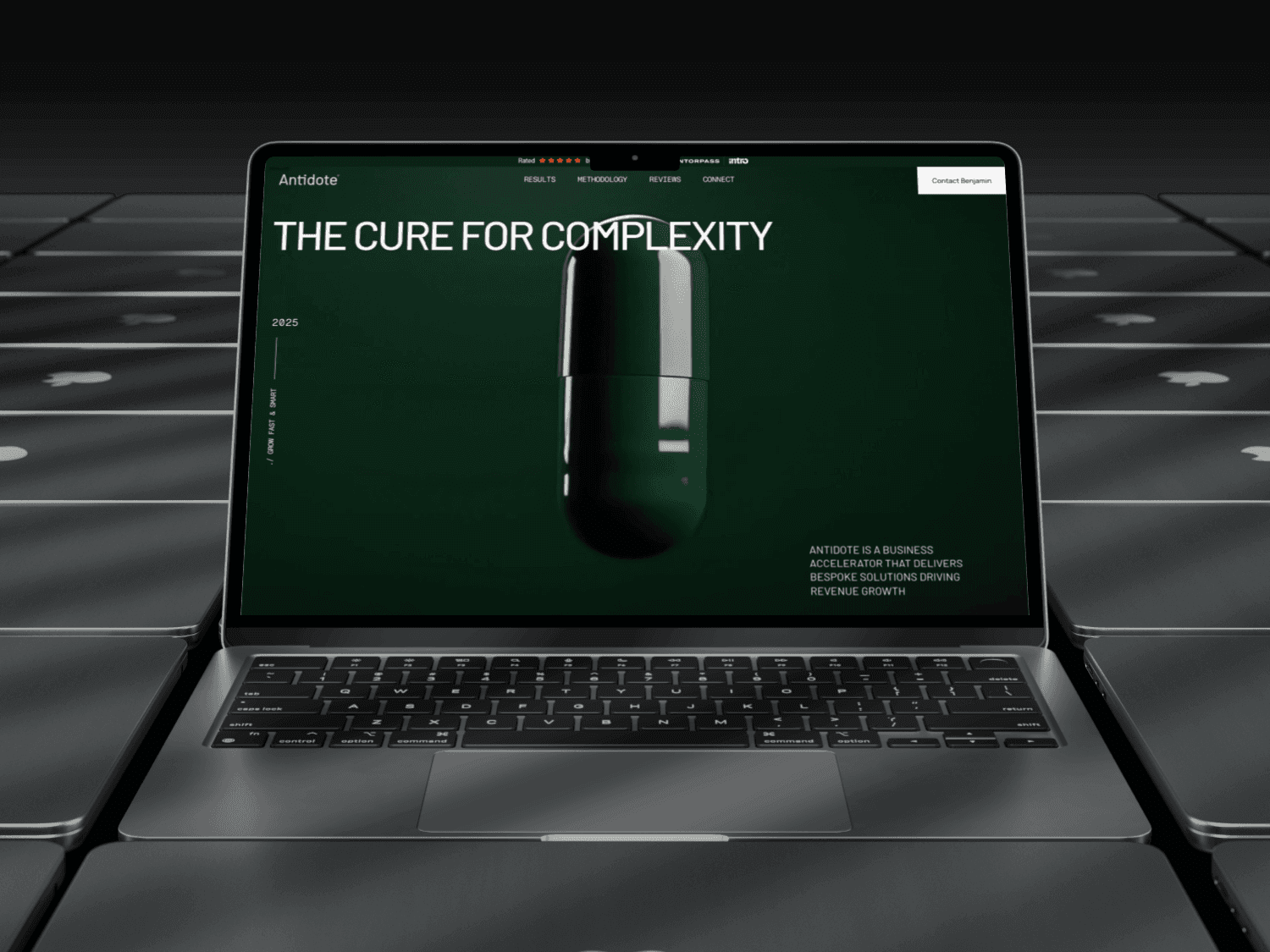 Laptop displaying the Antidote website hero section with the tagline “THE CURE FOR COMPLEXITY” and a sleek dark-green capsule visual, symbolizing clarity and business acceleration.