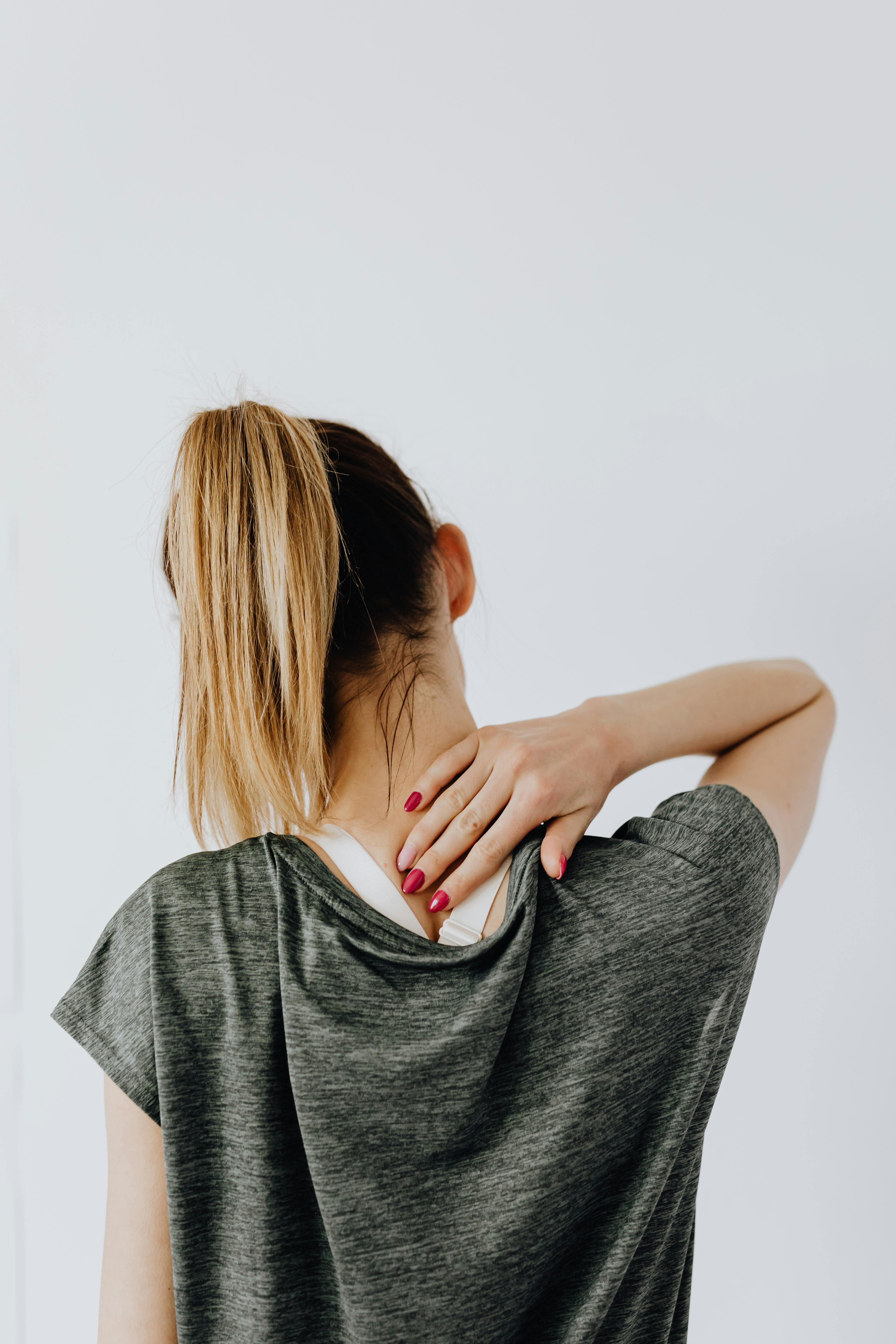 Chiropractor adjusting neck of individual with discomfort from daily strain 