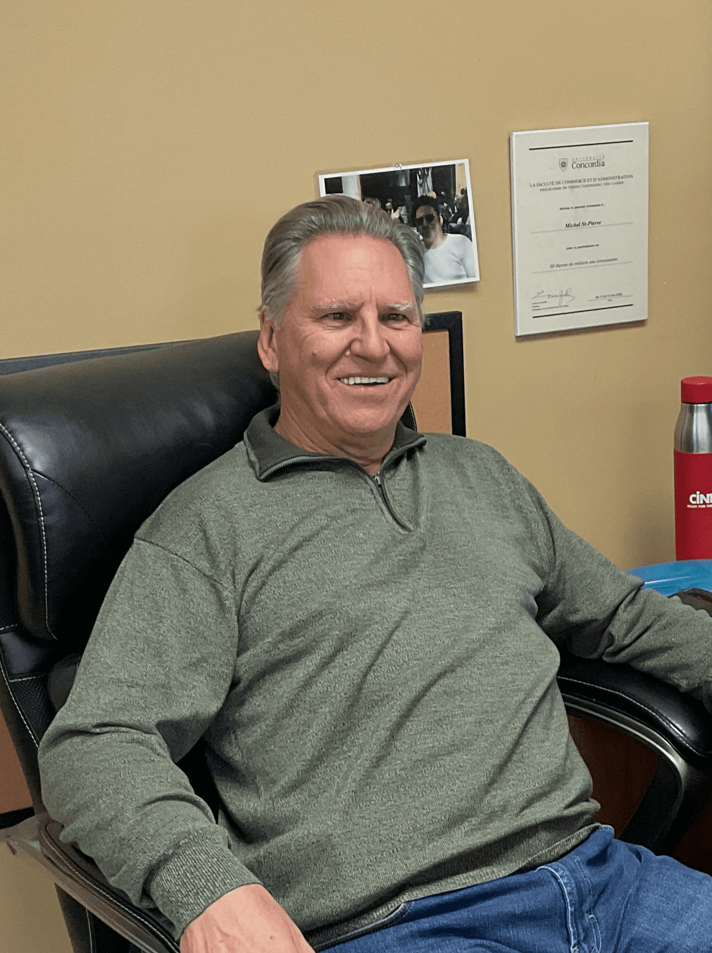 Portrait de Michel St-Pierre, membre de l’équipe administrative, assis dans un fauteuil de bureau.