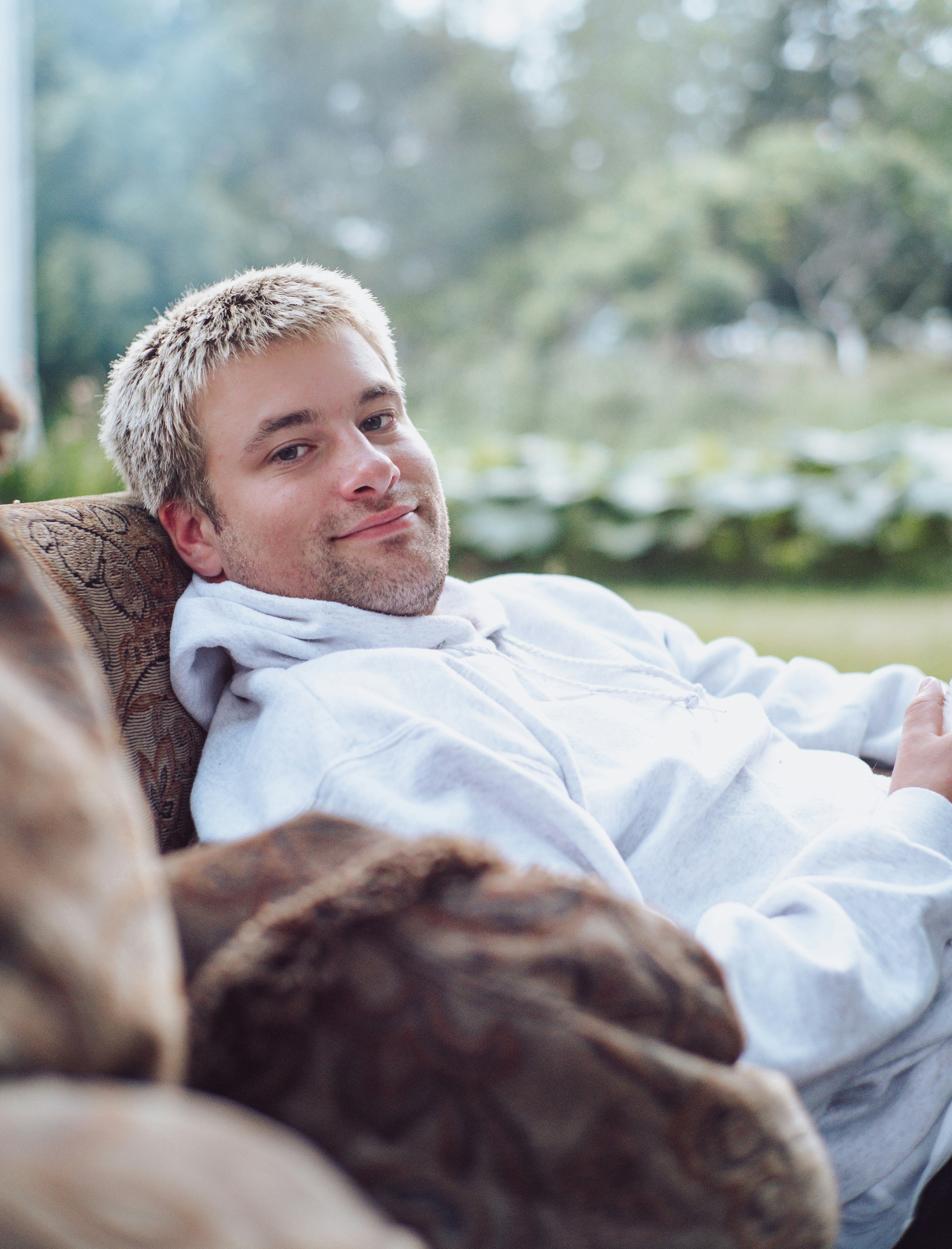 man in white dress shirt lying on brown textile