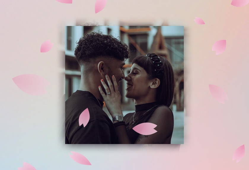 Sweet and intimate photo engagement invitation with falling pink petals and soft lighting.