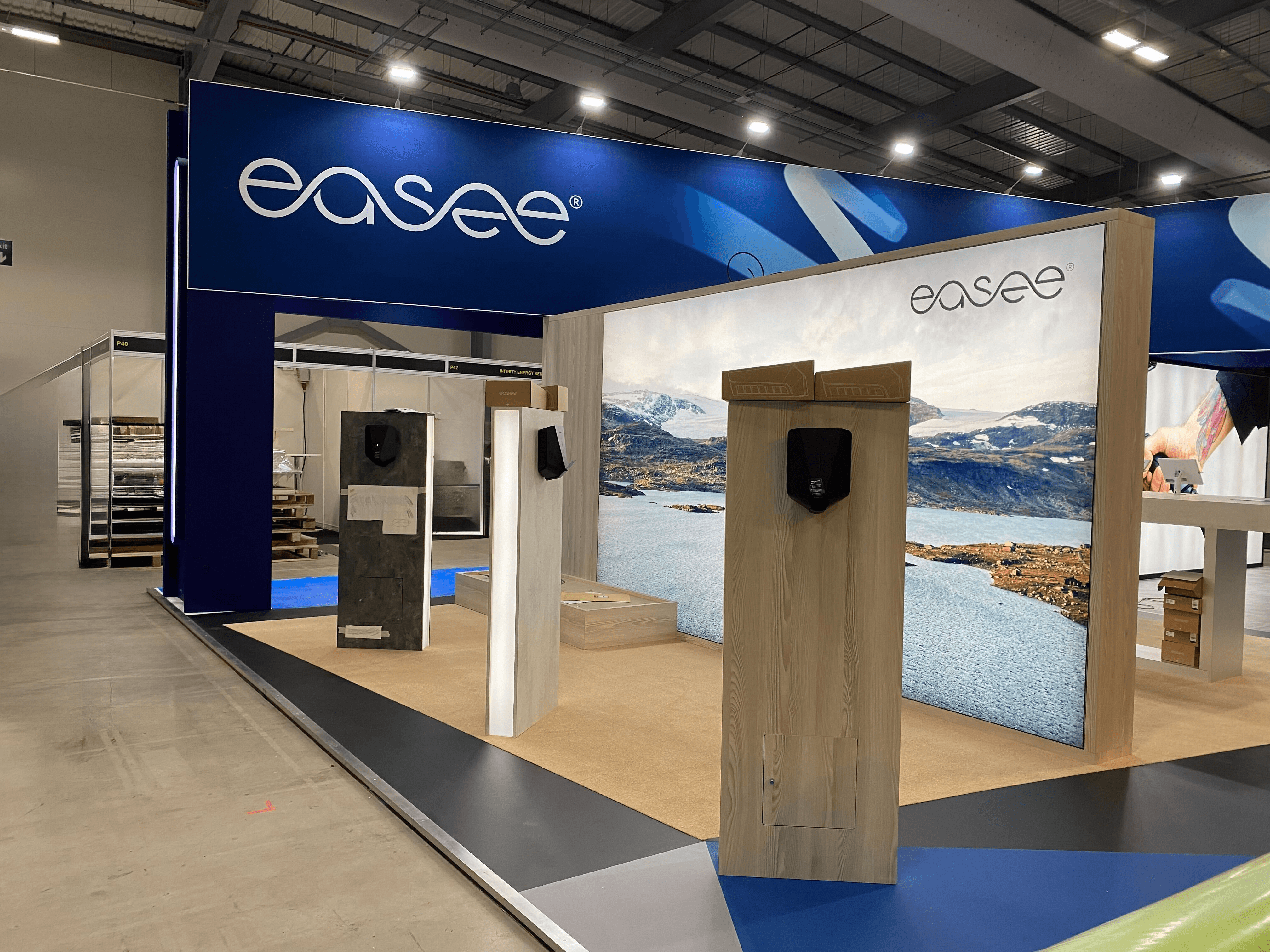Modern home office setup with a monitor, ergonomic chair, keyboard, and indoor plants near a window with blinds.