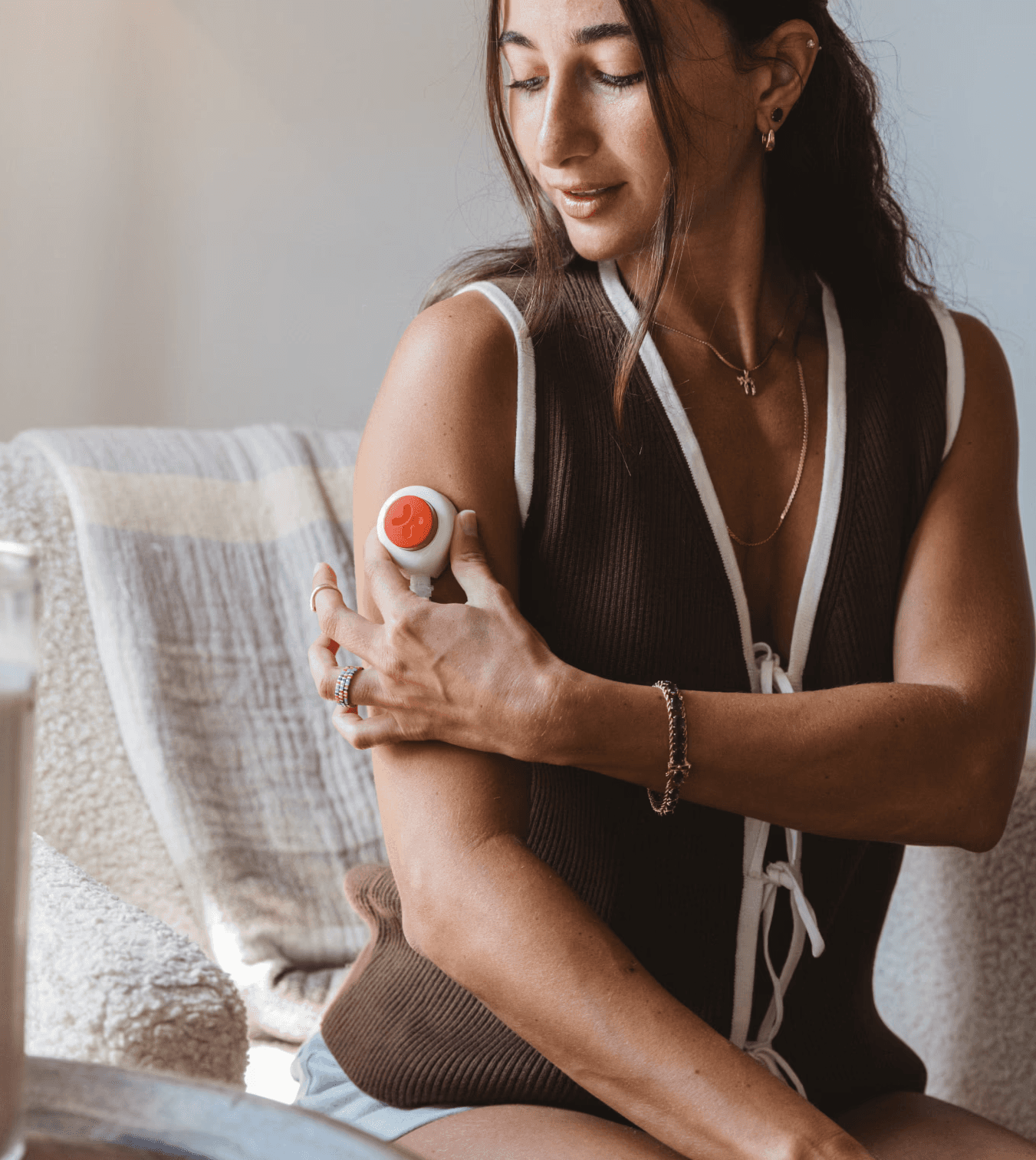 Woman collecting a blood sample from her upper arm at home.