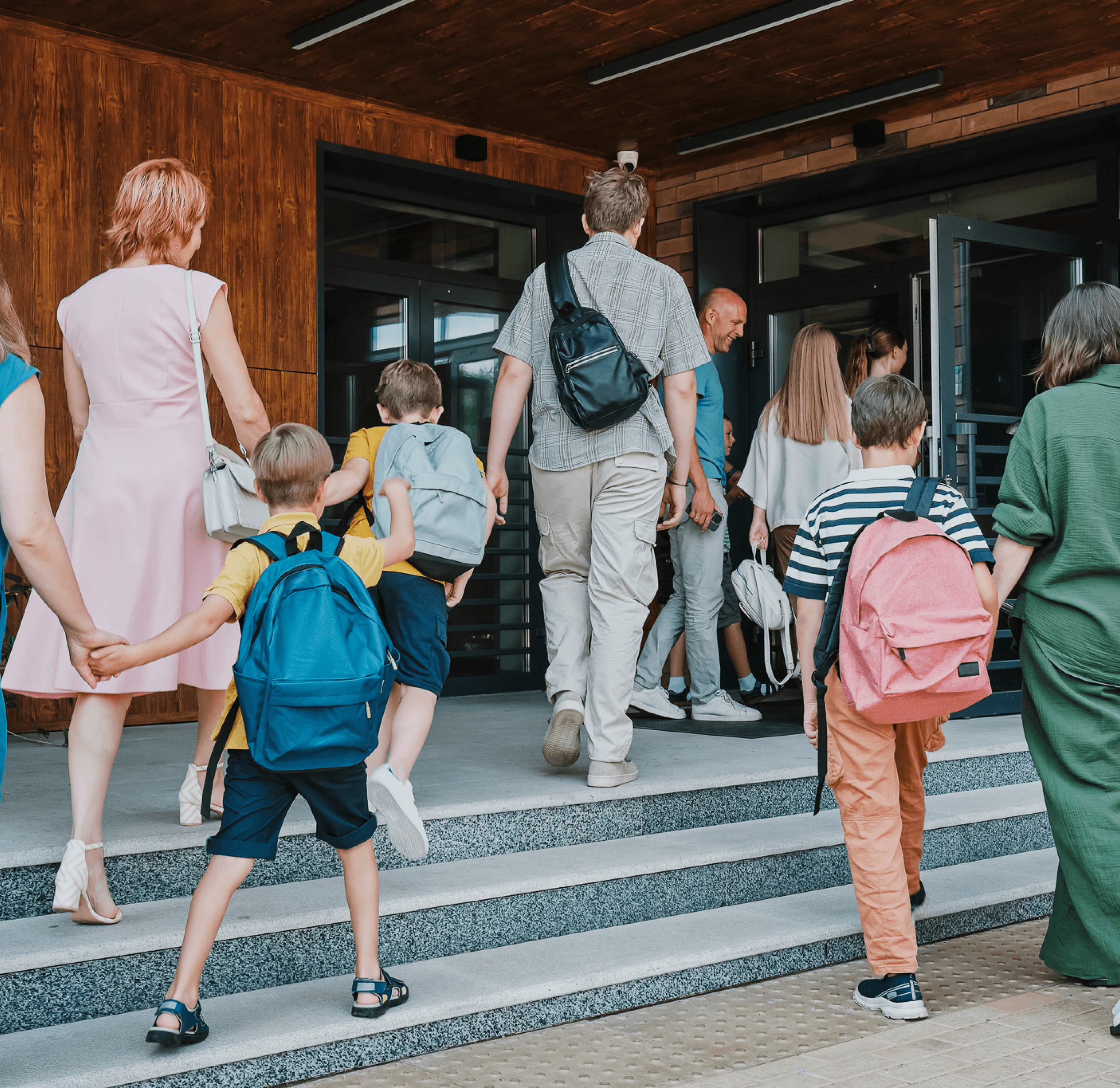Kinderen lopen met ouders de klas in