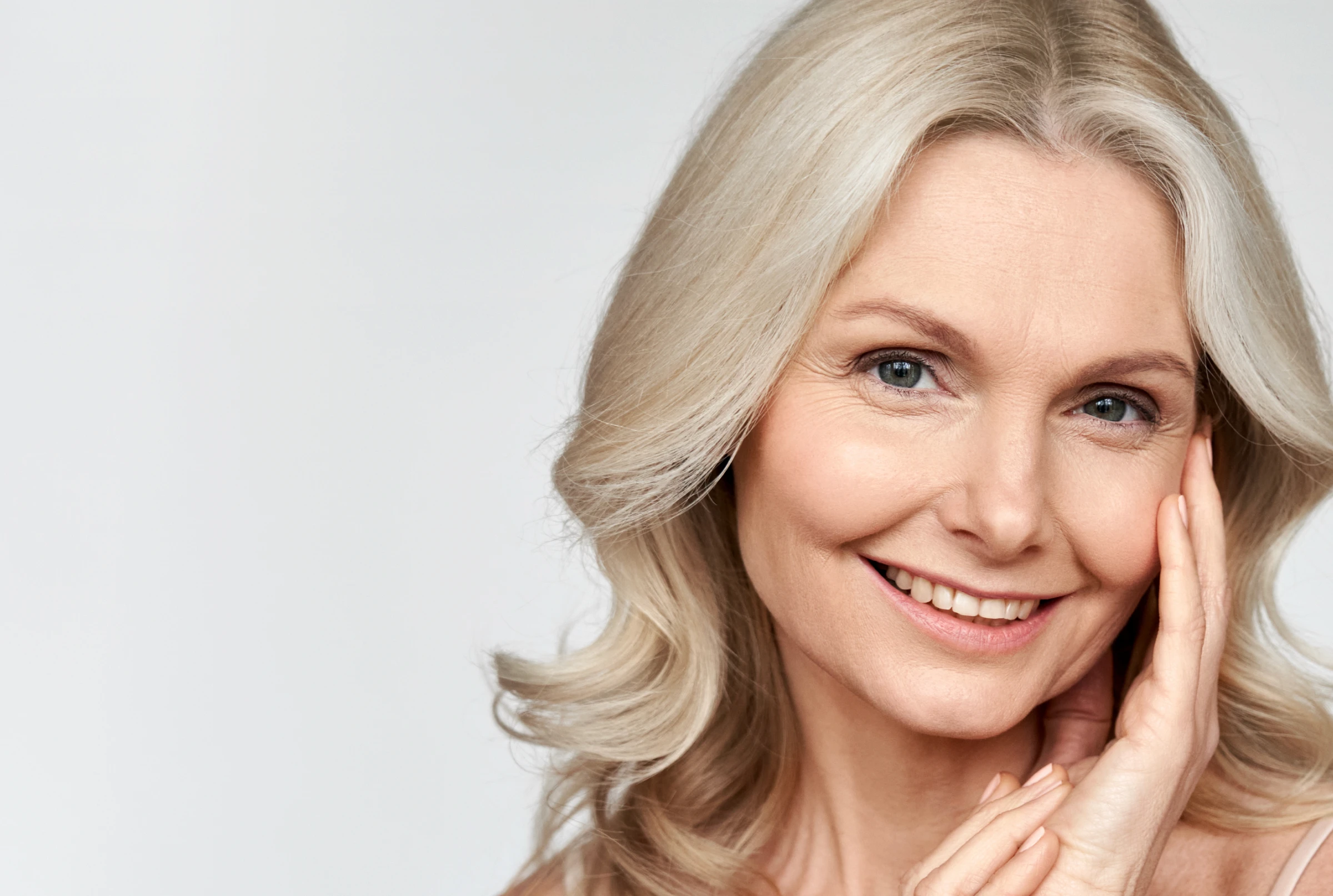 Kobieta z uśmiechem prezentująca efekty bondingu na swoich zębach.