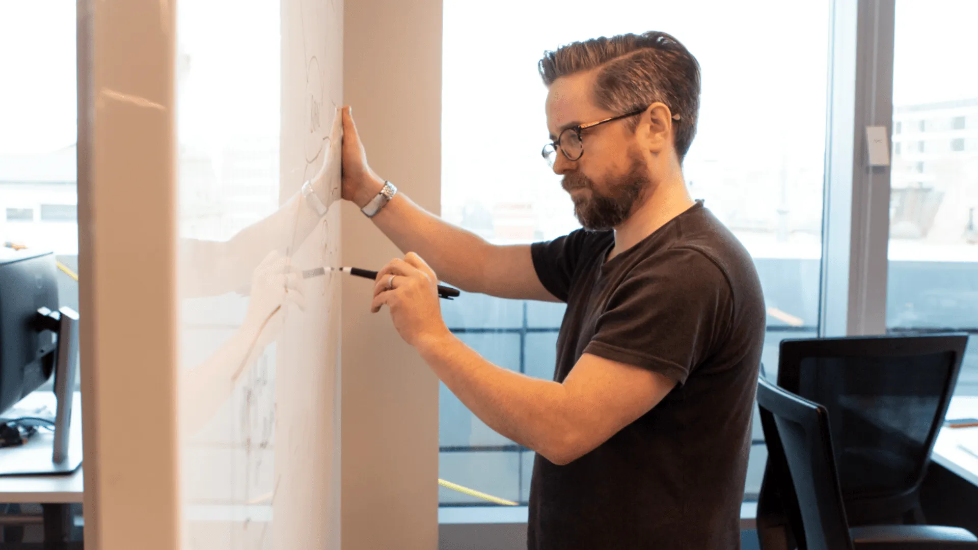 A person drawing an experience map on a wall