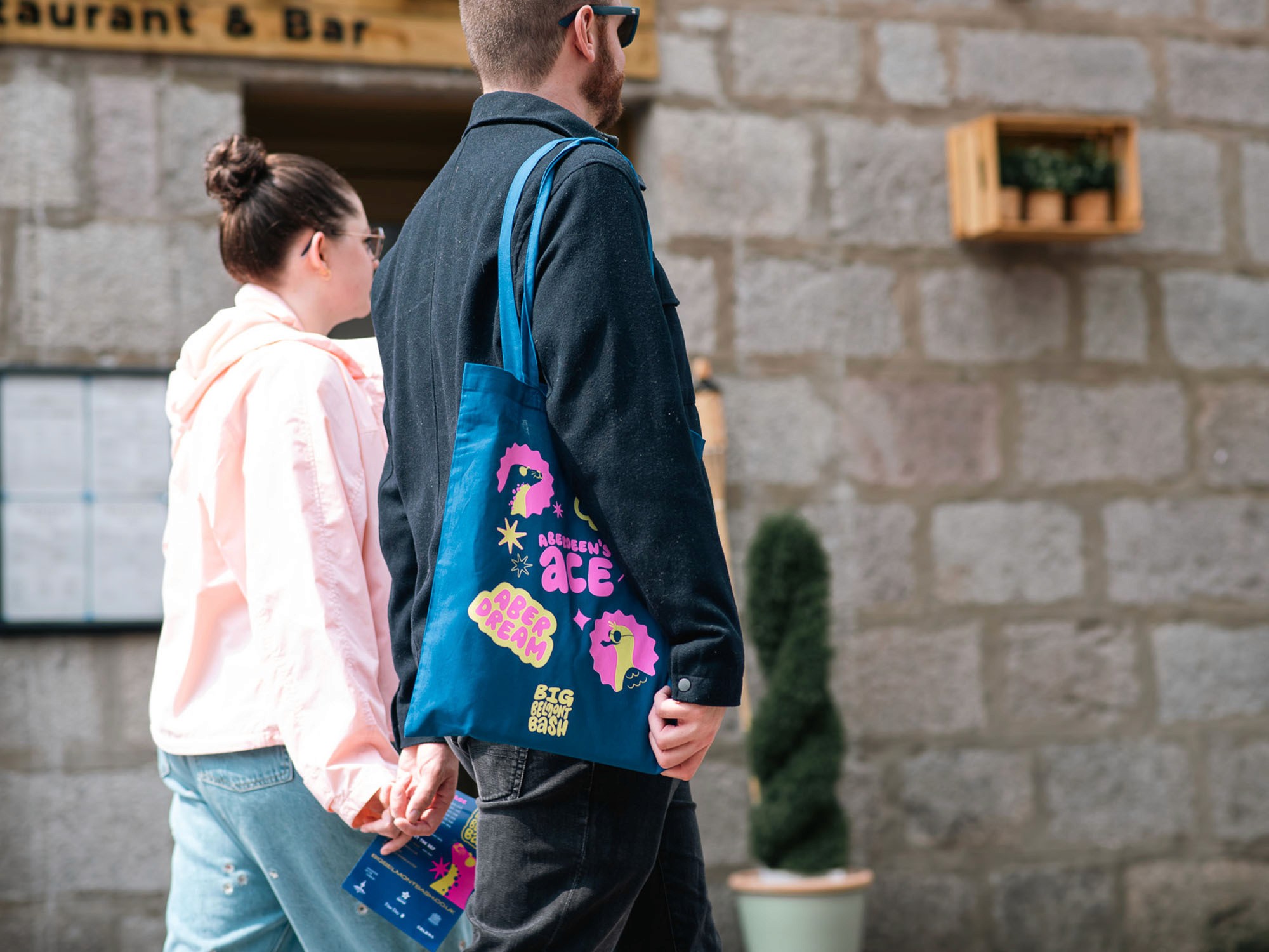 man and woman walking down street holding hands