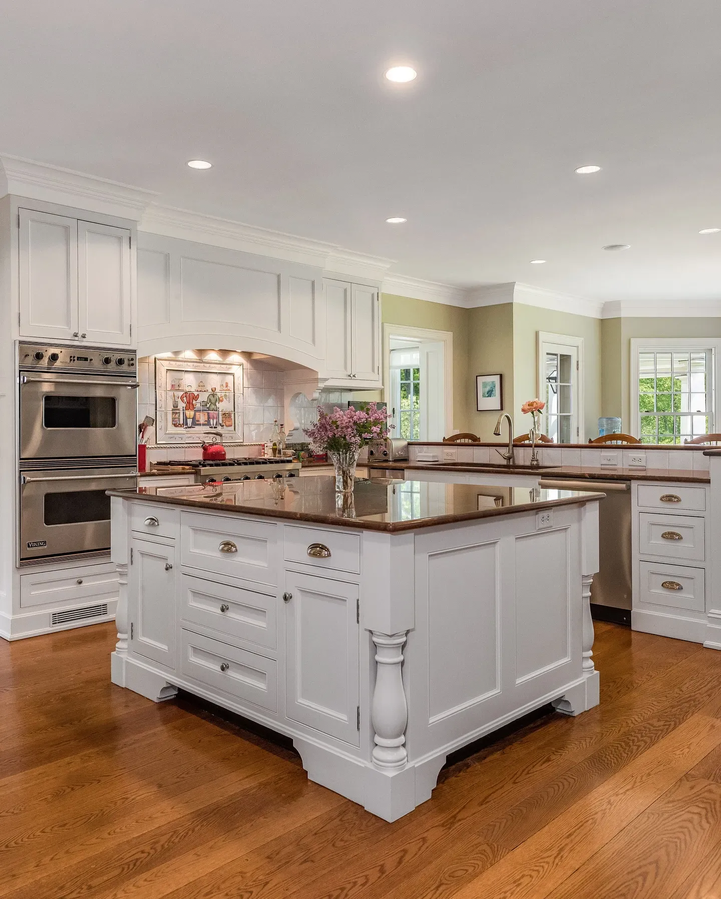 A modern kitchen with white cabinets, a large island, and appliances.