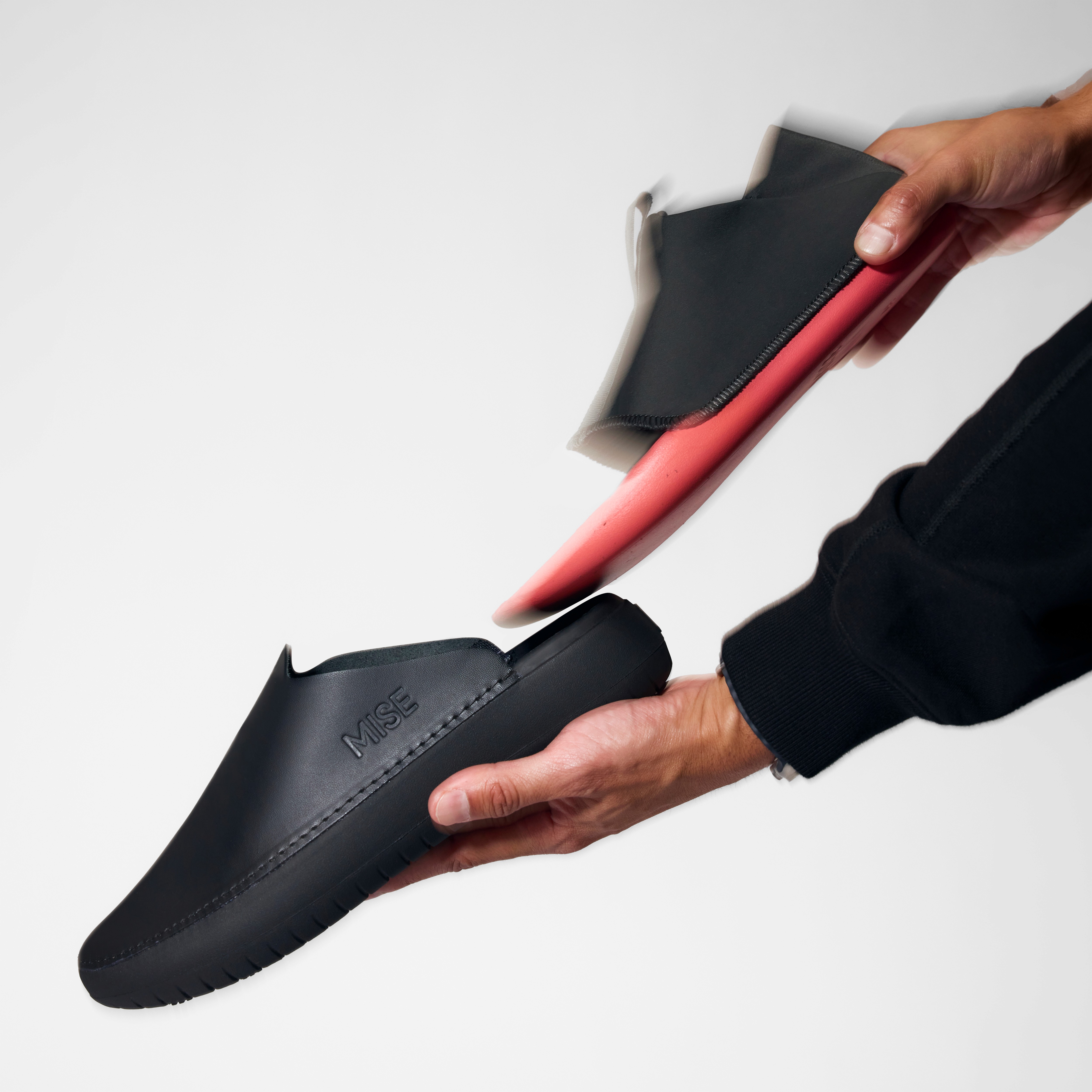 The Relaxed 2 MISE kitchen shoe insole in black being inserted into shell