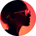 Silhouetted profile of a person wearing round sunglasses, set against a vivid red background. The mood is stylish and enigmatic.