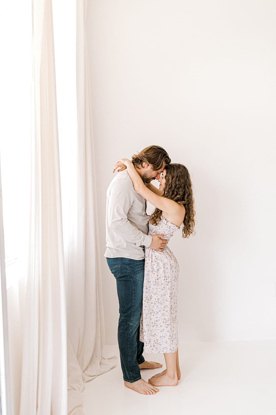 The couple smiles brightly as they hold each other close during their natural light engagement shoot at Revelator Studio, Shreveport.