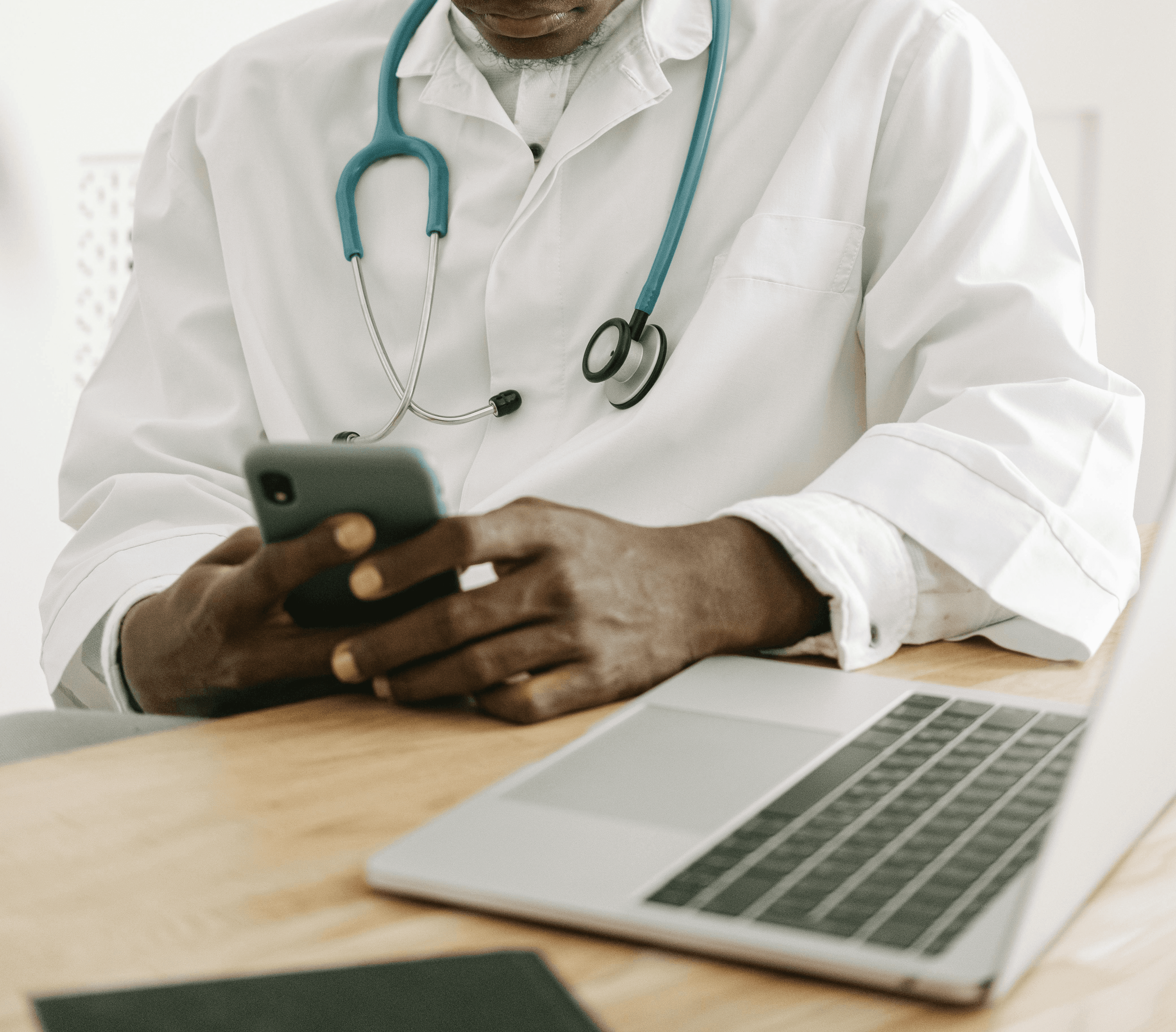 A smiling woman doctor is sitting at her desk and looking at a computer screen showing a medical screening test.