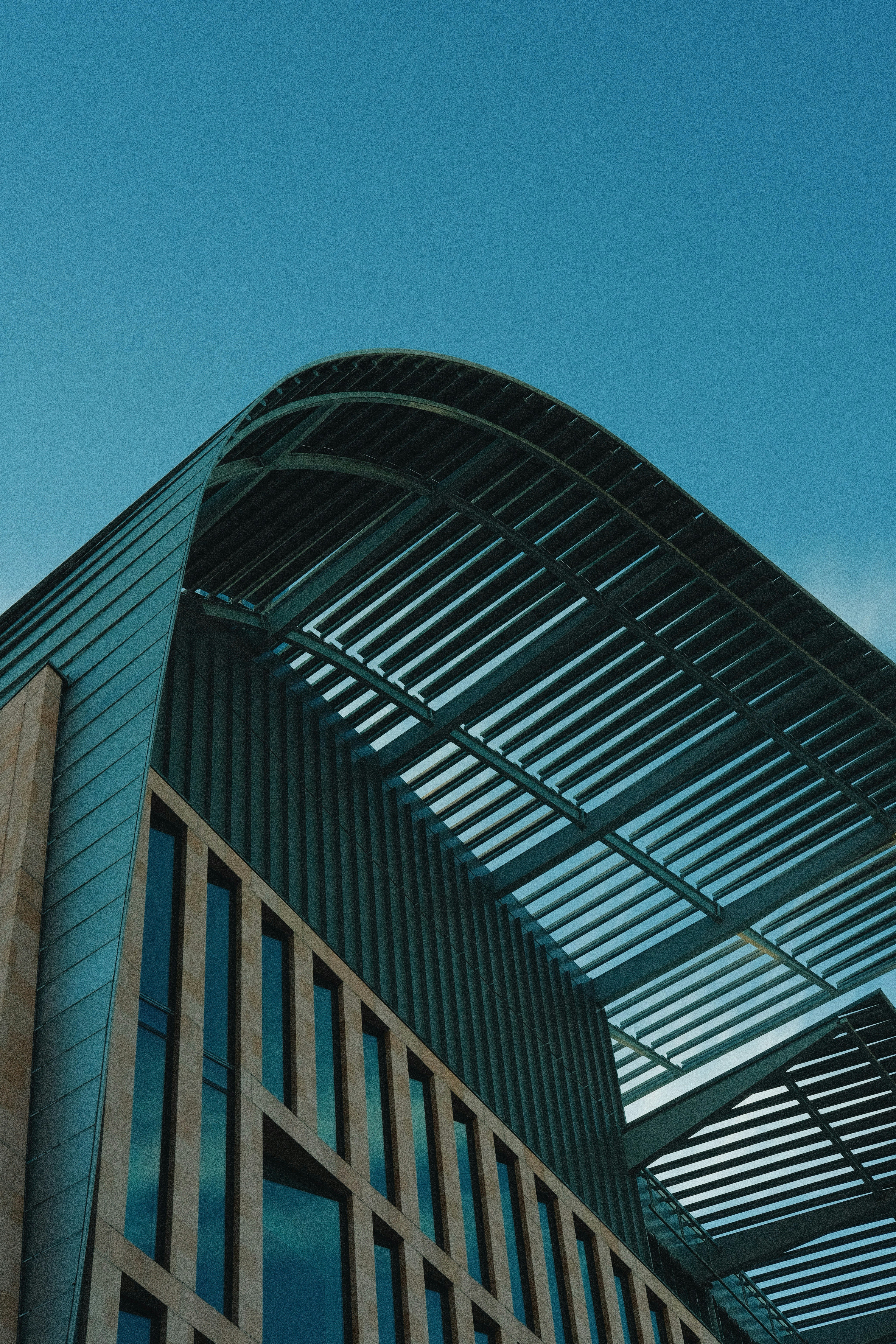 Modern building with curved roof against blue sky