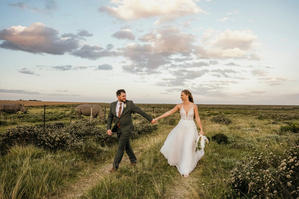 Bride and groom walking together along safari path at Eastern Cape venue