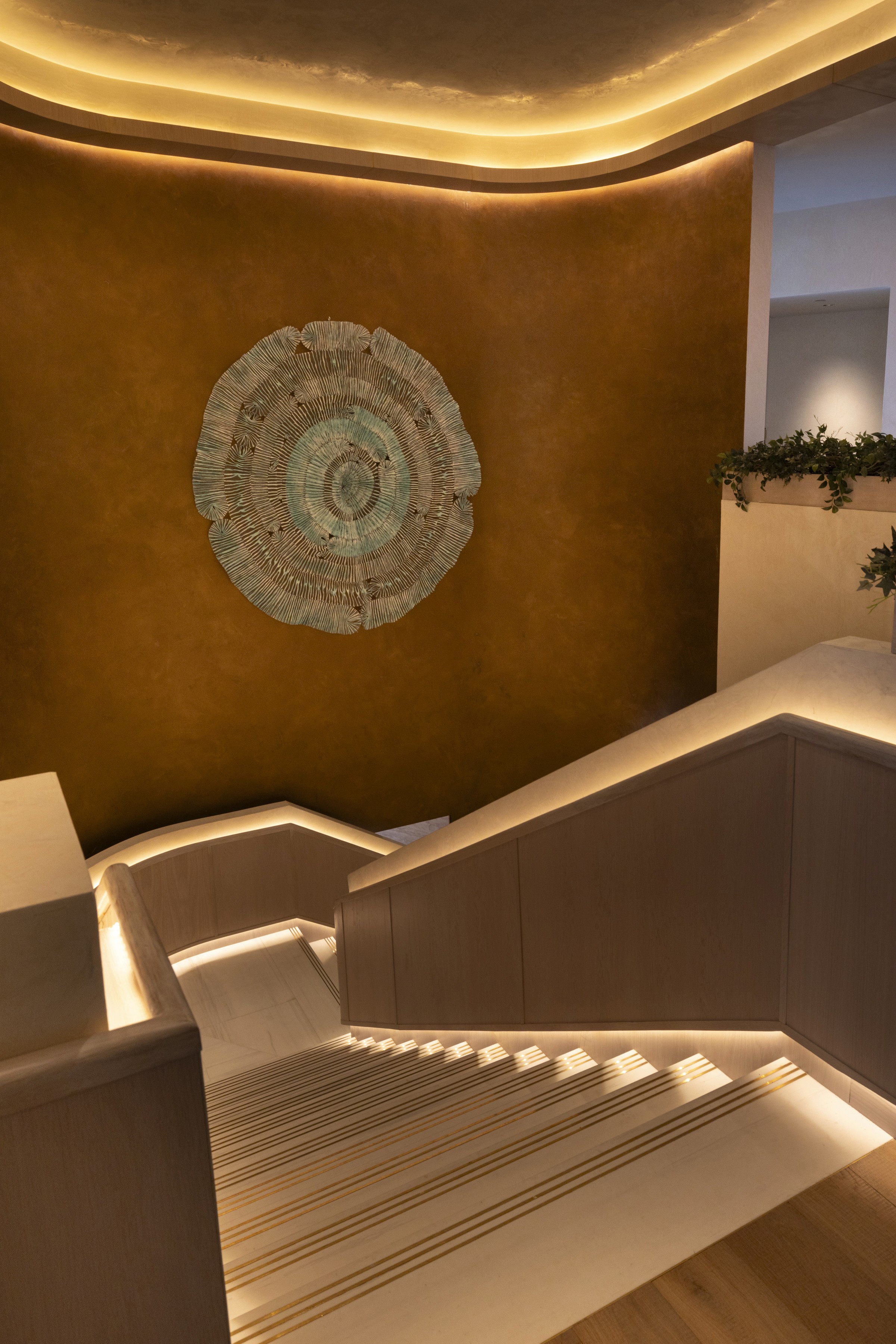 Elegant dining room with a long table set for a meal, featuring decorative walls and soft lighting.