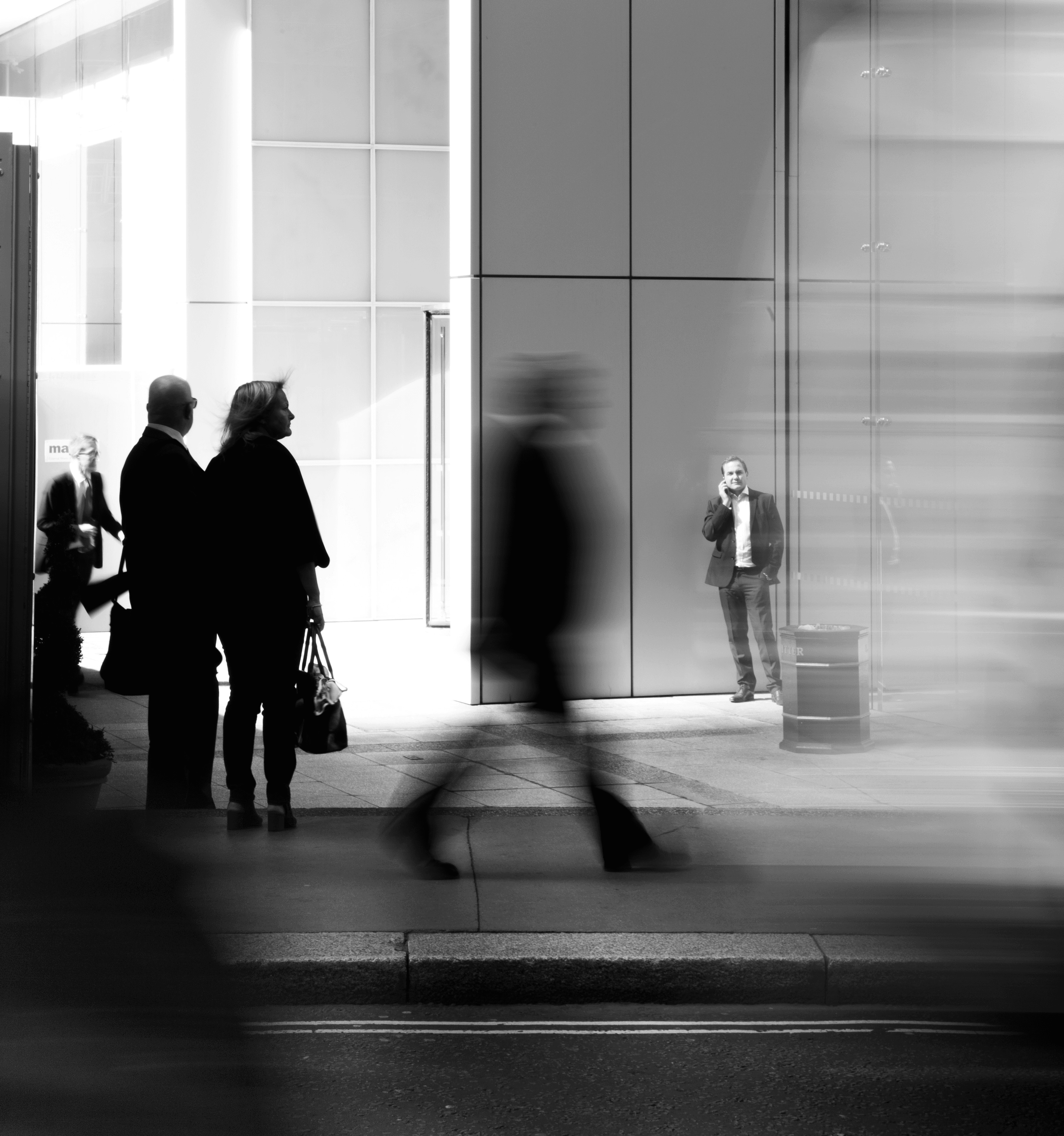 grayscale photo of people walking towards building