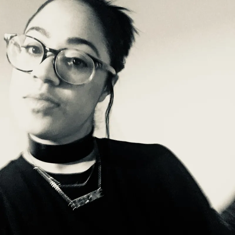 Black and white portrait of a smiling person with curly hair