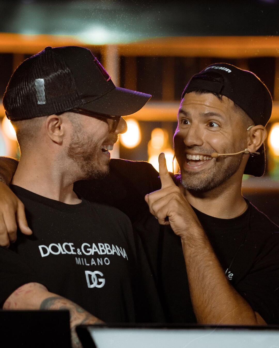 Fer Palacio riendo y chocando manos con el Kun Agüero en un ambiente relajado.