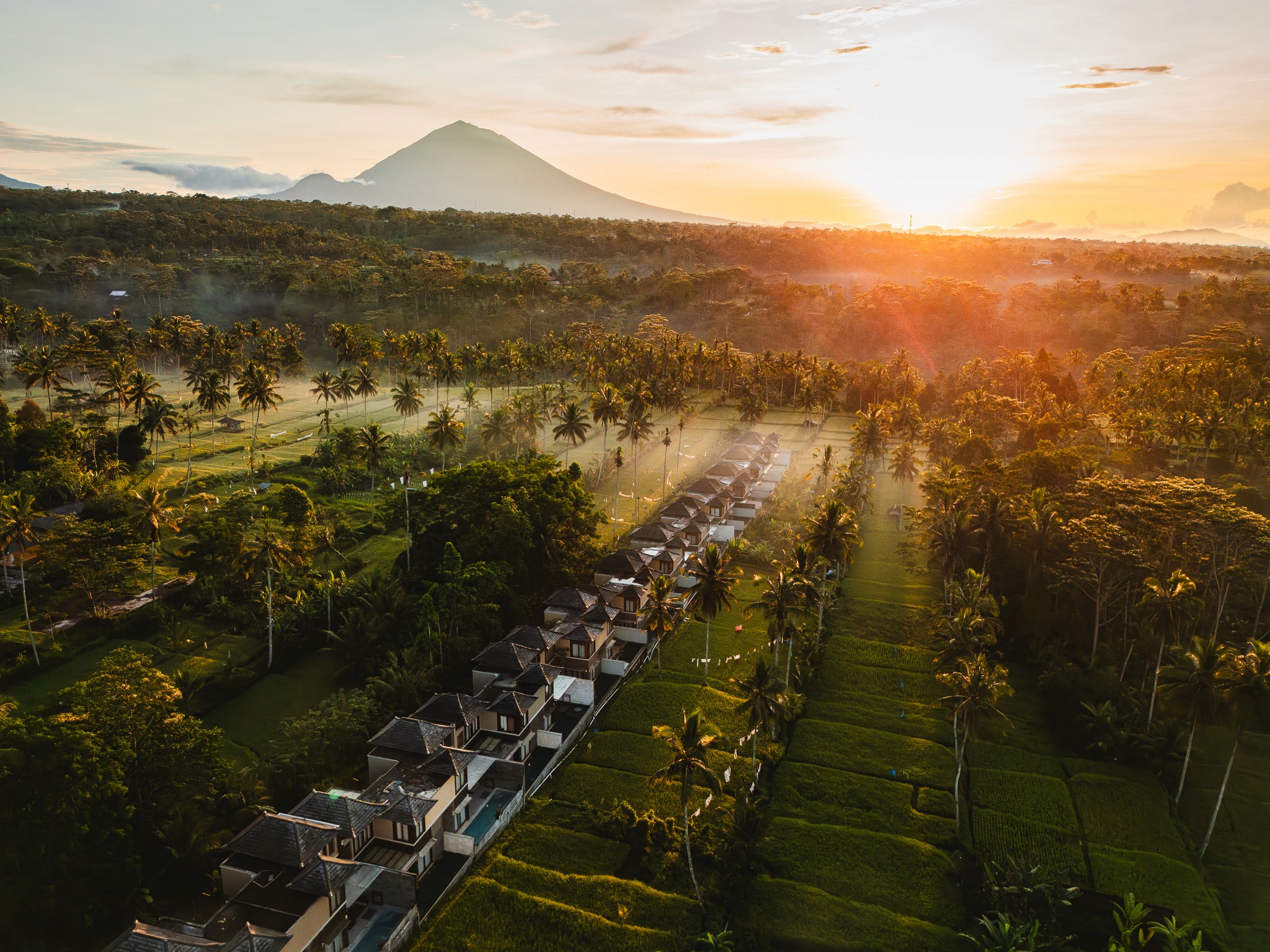 Sonnenaufgang über den tropischen Reisfeldern von Bali – Luftaufnahme der Khastana Hadi Luxury Villas, Ubud