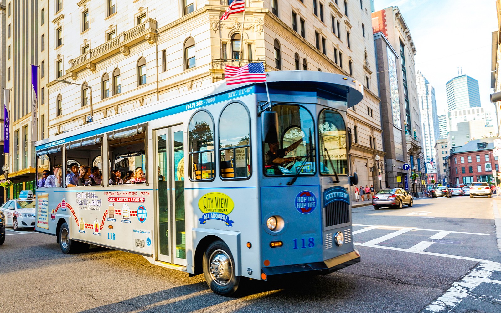 Tourists on a hop-on hop-off trolley in downtown Boston.