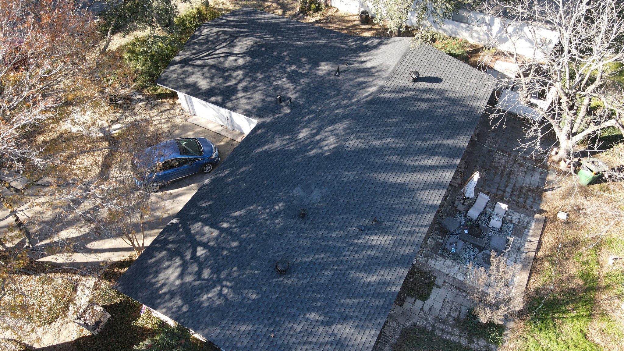 Crossed hip roof with turbine vents and architectural shingles, providing both an attractive design and effective ventilation.