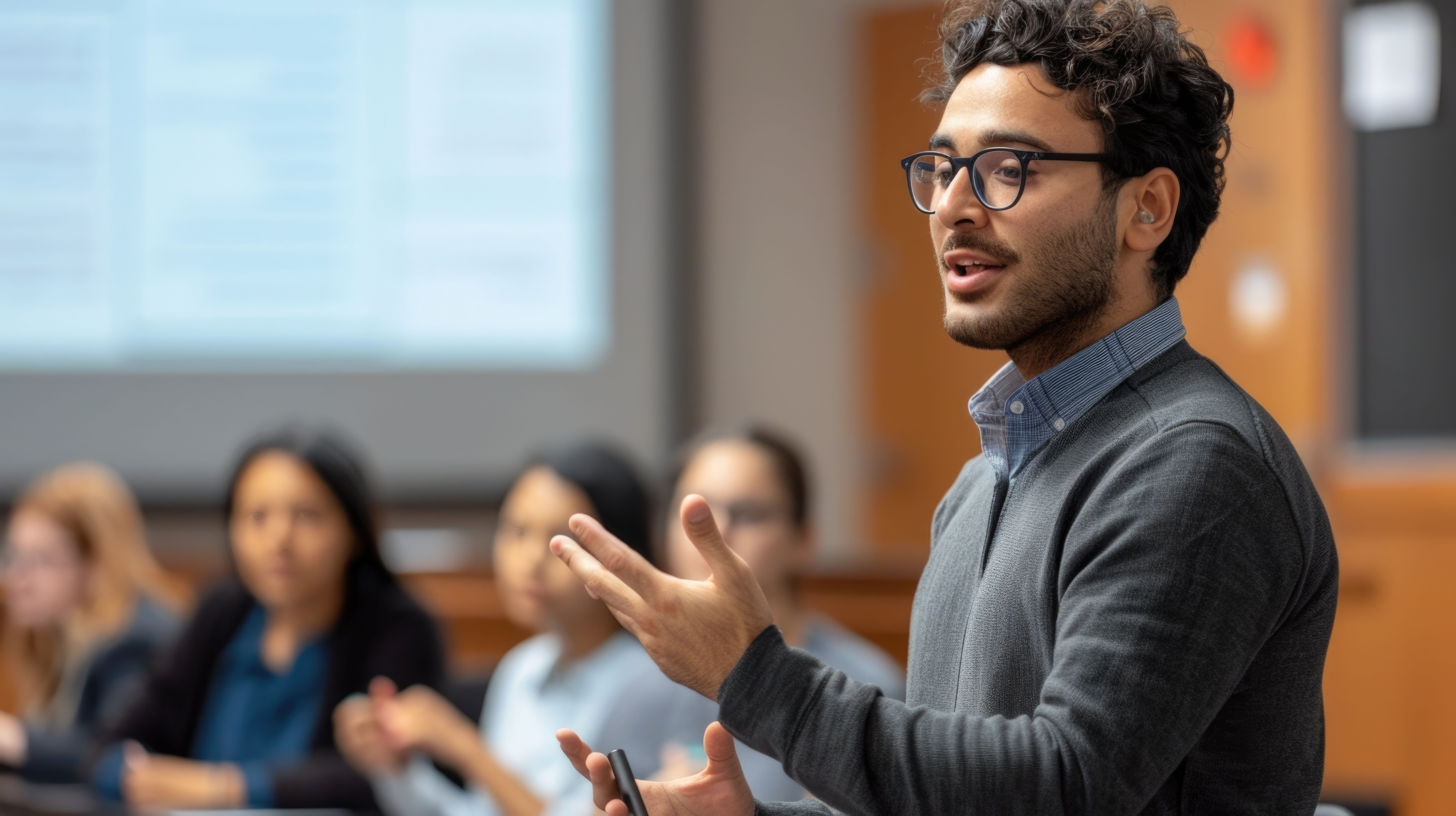 Trainer presenting to professionals during a management systems training session, with participants listening in a classroom setting.