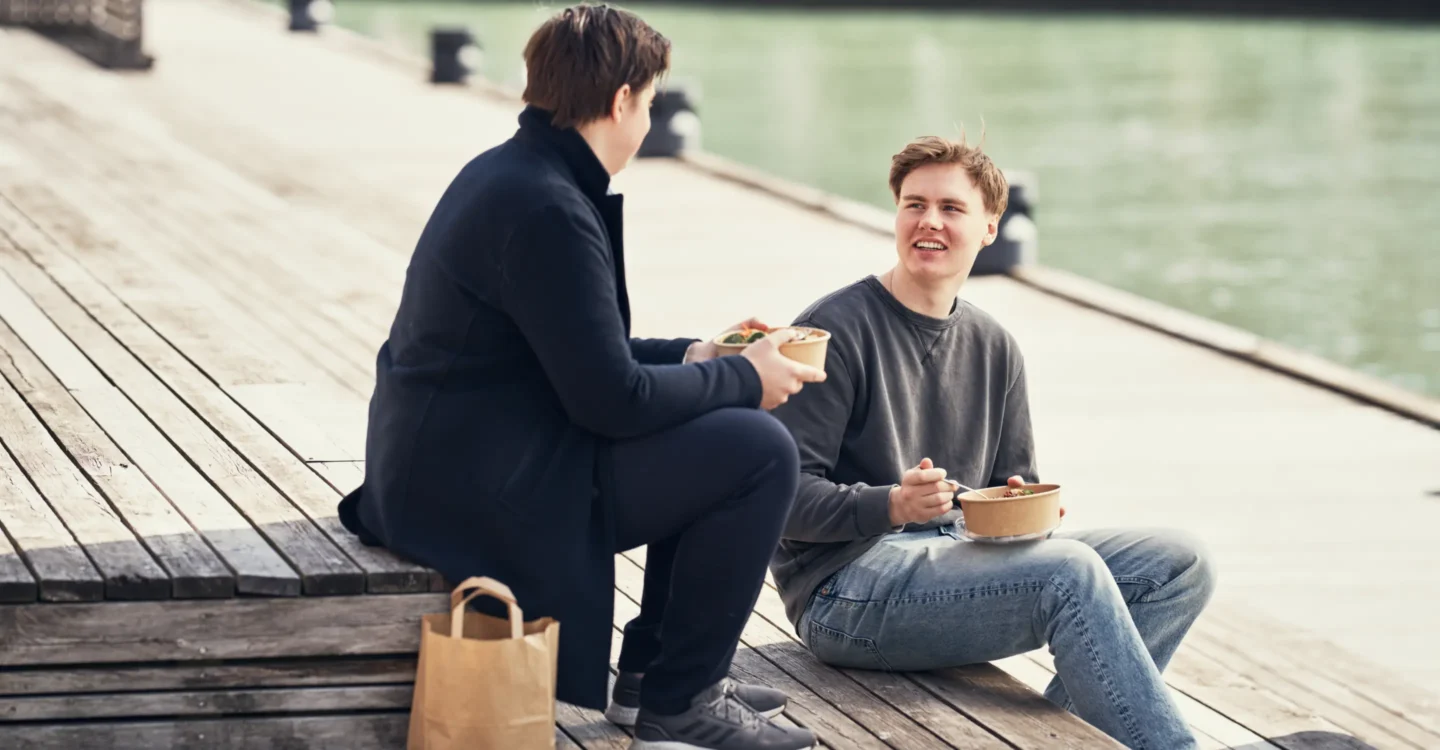 Two students eating lunch by the dock