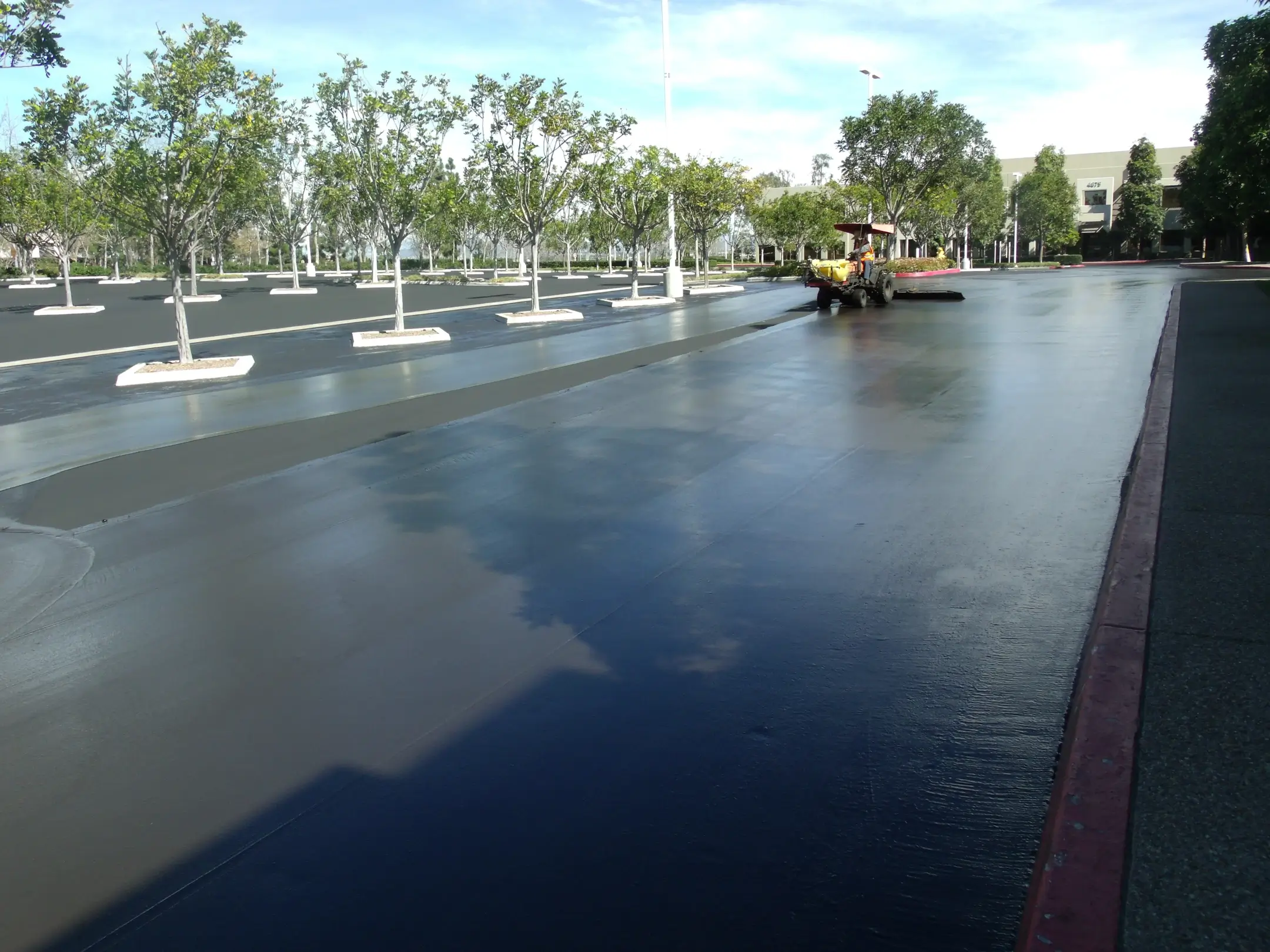 Tractor seal coating a parking lot