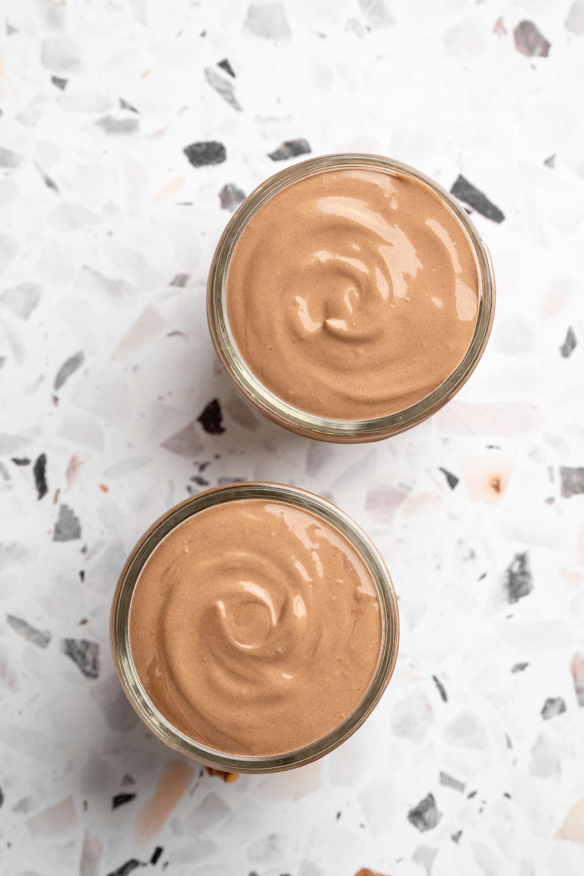 Two small glasses with chocolate cottage cheese mousse.