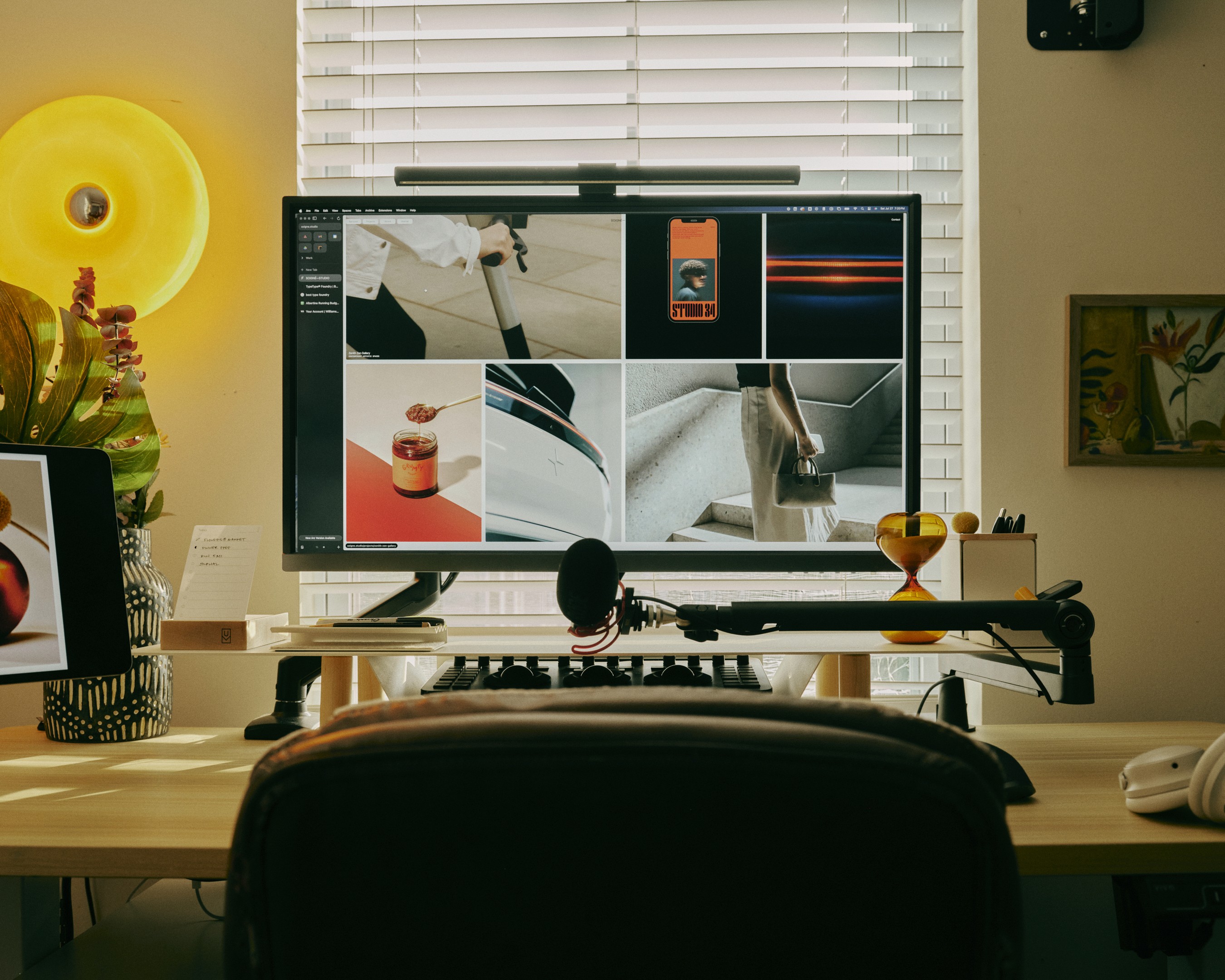 Backside of a person with a had and curly hairs sits in front of a screen in a room