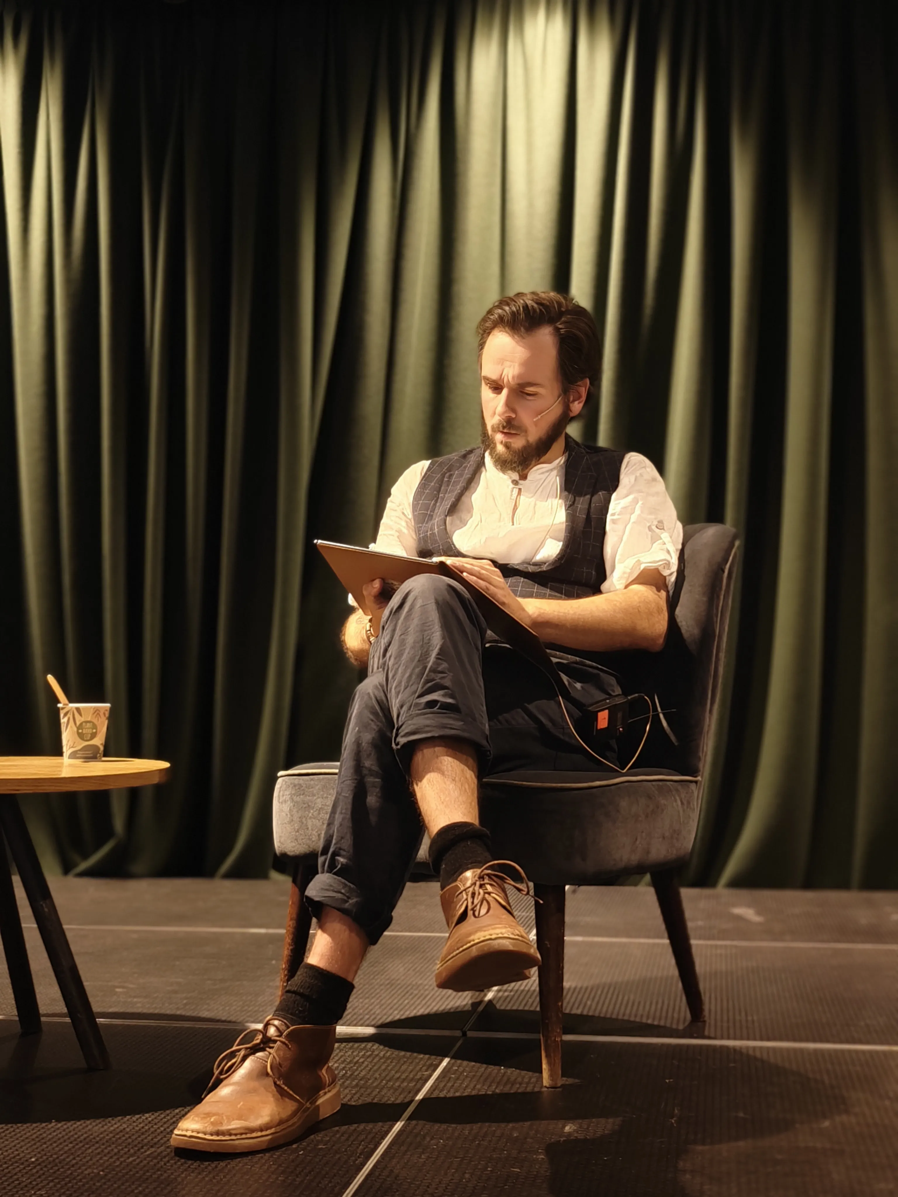 A person sitting down and talking under a spotlight