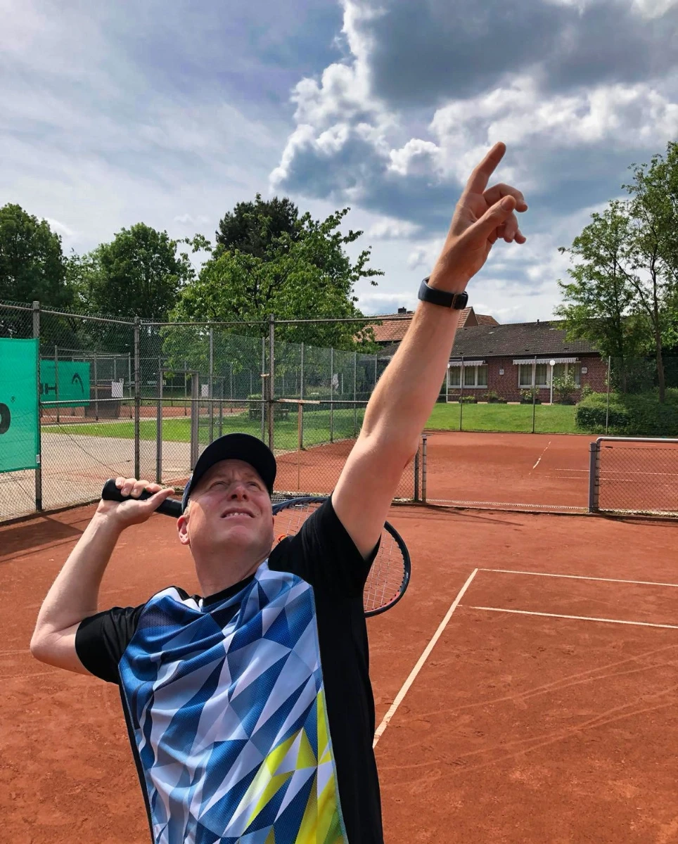 a man holding a tennis racquet on a tennis court