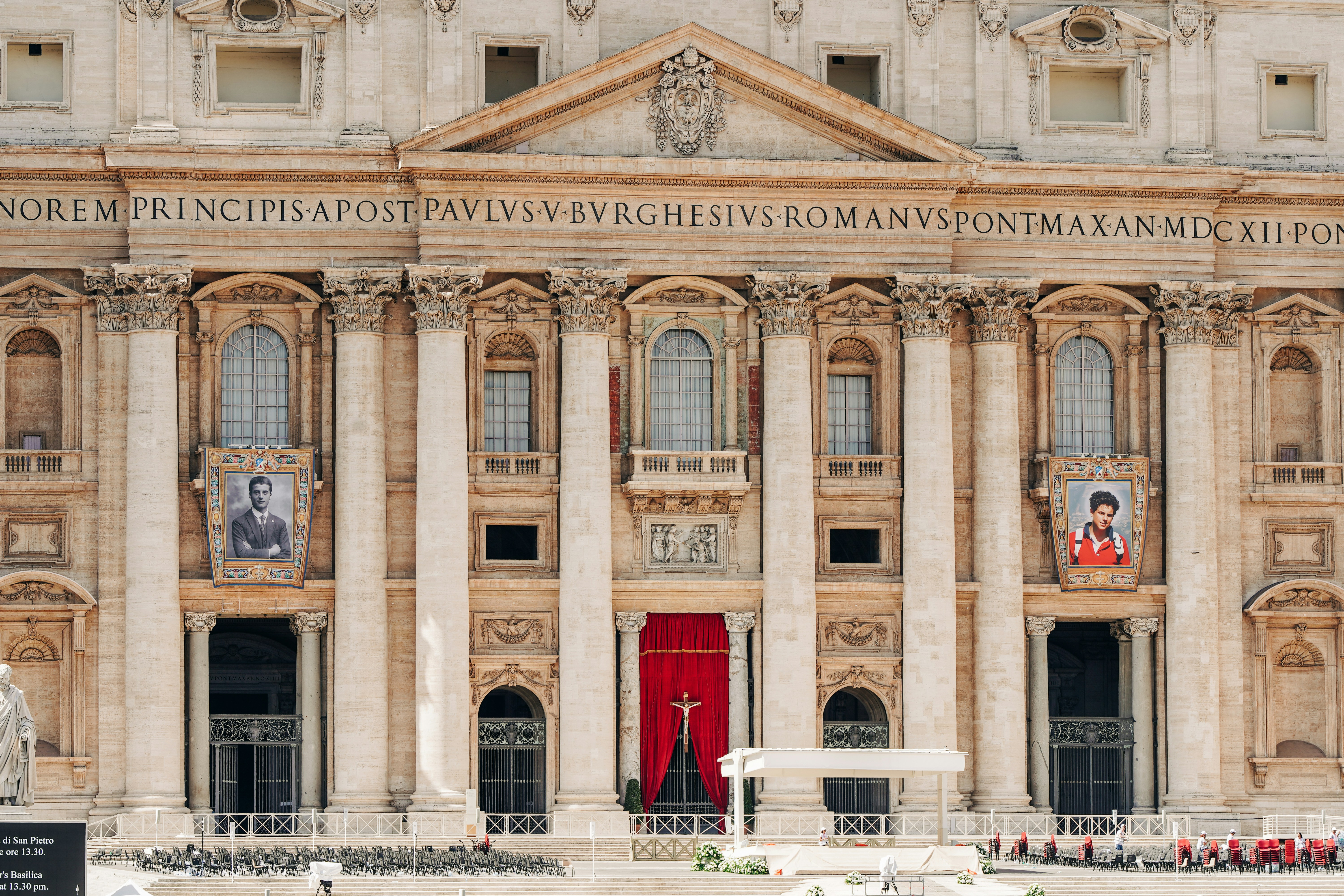 St. peter's basilica facade with red drapery and banners.