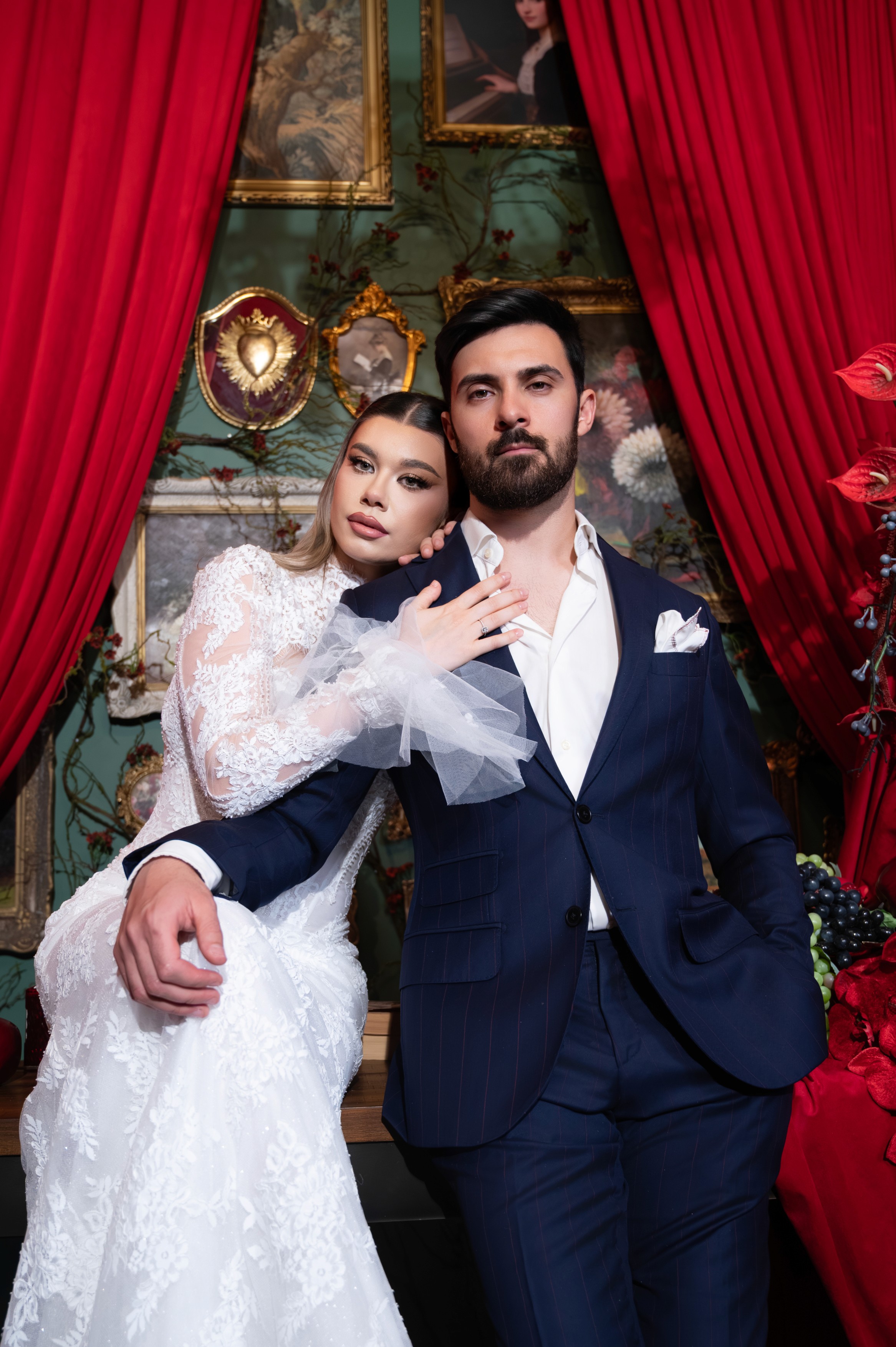 Mire și mireasă fotografiați într-un decor elegant cu draperii roșii și accente vintage, ședință foto de nuntă în București