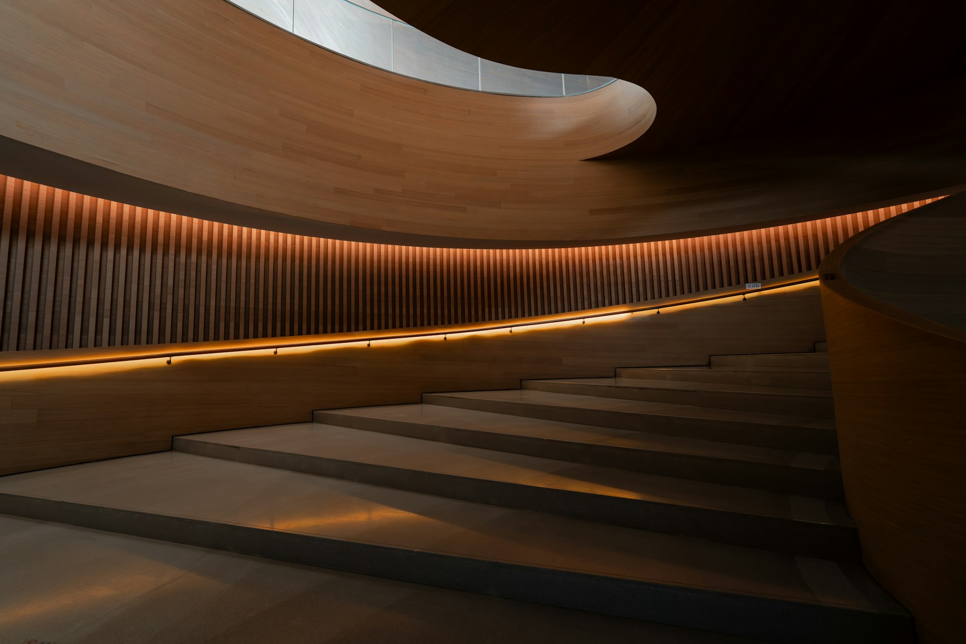 Reflecting pool beneath a low curved roof with planted edges