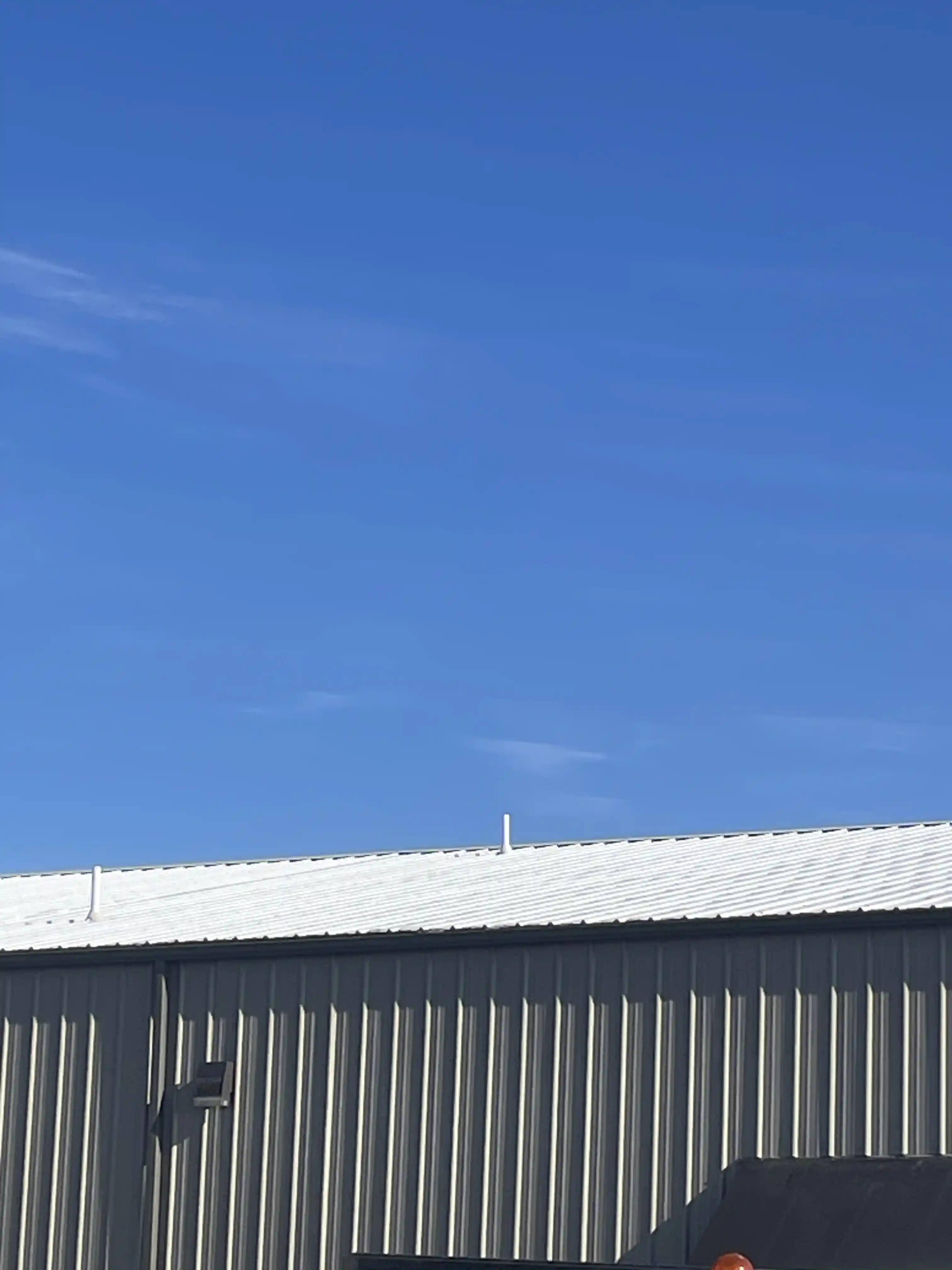 Un toit commercial métallique recouvert d'un revêtement imperméable blanc acrylique Rub-R-Roof