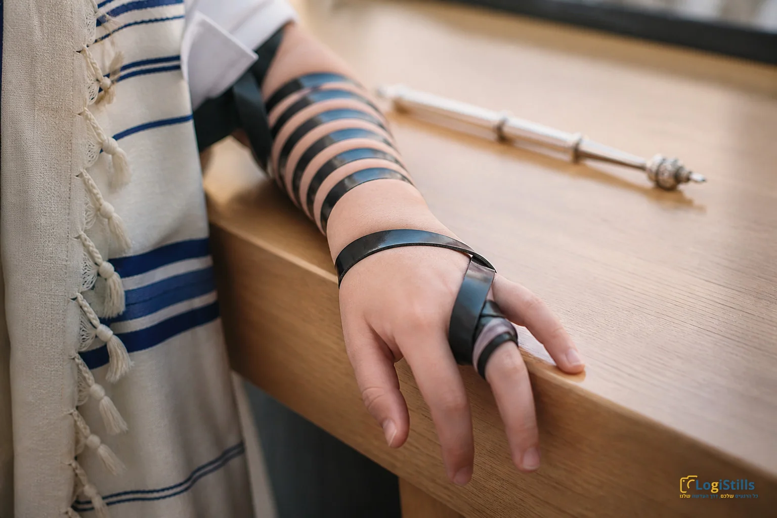 תקריב יד עם תפילין וטלית לצד יד הכסף של ספר התורה