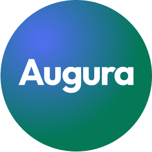 Smiling man with light brown hair and stubble, wearing a khaki shirt in natural light