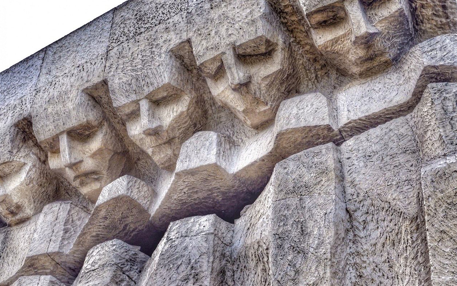 Nærbilde av utskårne ansikter på monumentet til ofrene for fascismen i Plaszow, Krakow.