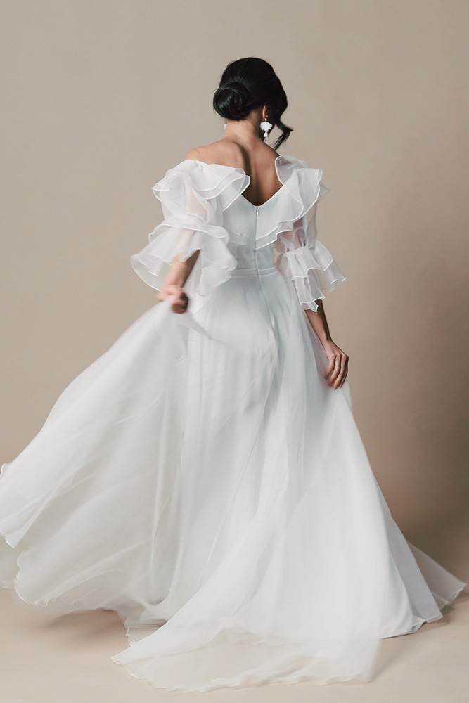 Bride in an off-shoulder gown with a full tulle skirt caught in movement, fine art bridal editorial by Eva Sitko