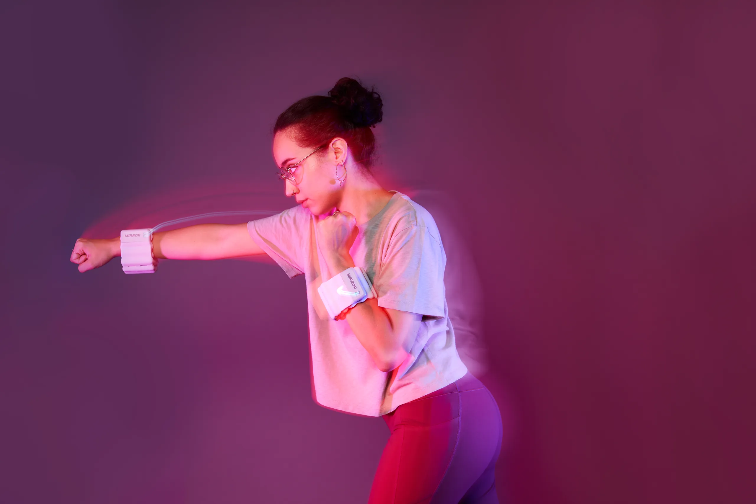 Person exercising while wearing Mirror connected weights around both wrists