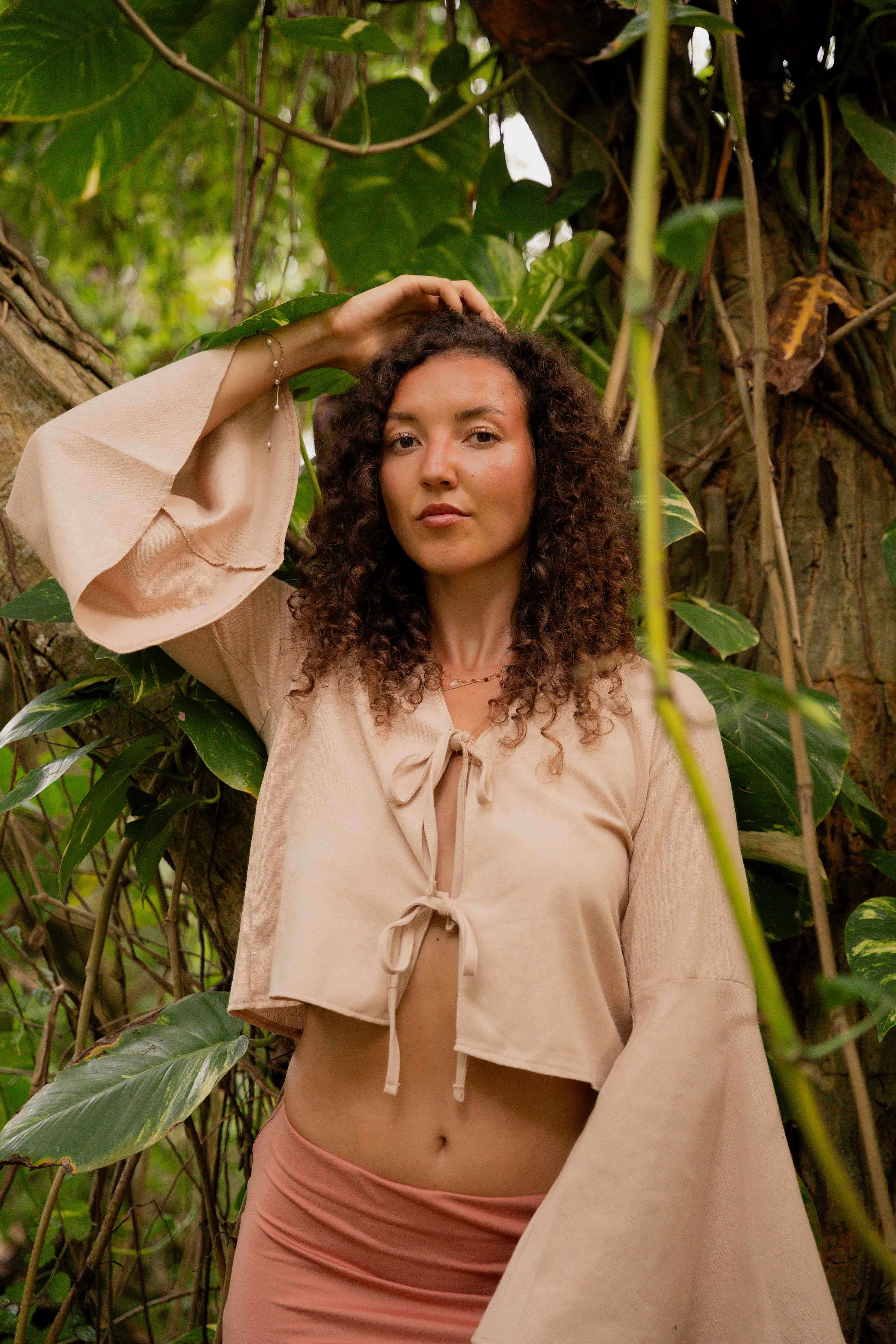 Girls posing on tree showing the clothing she is wearing