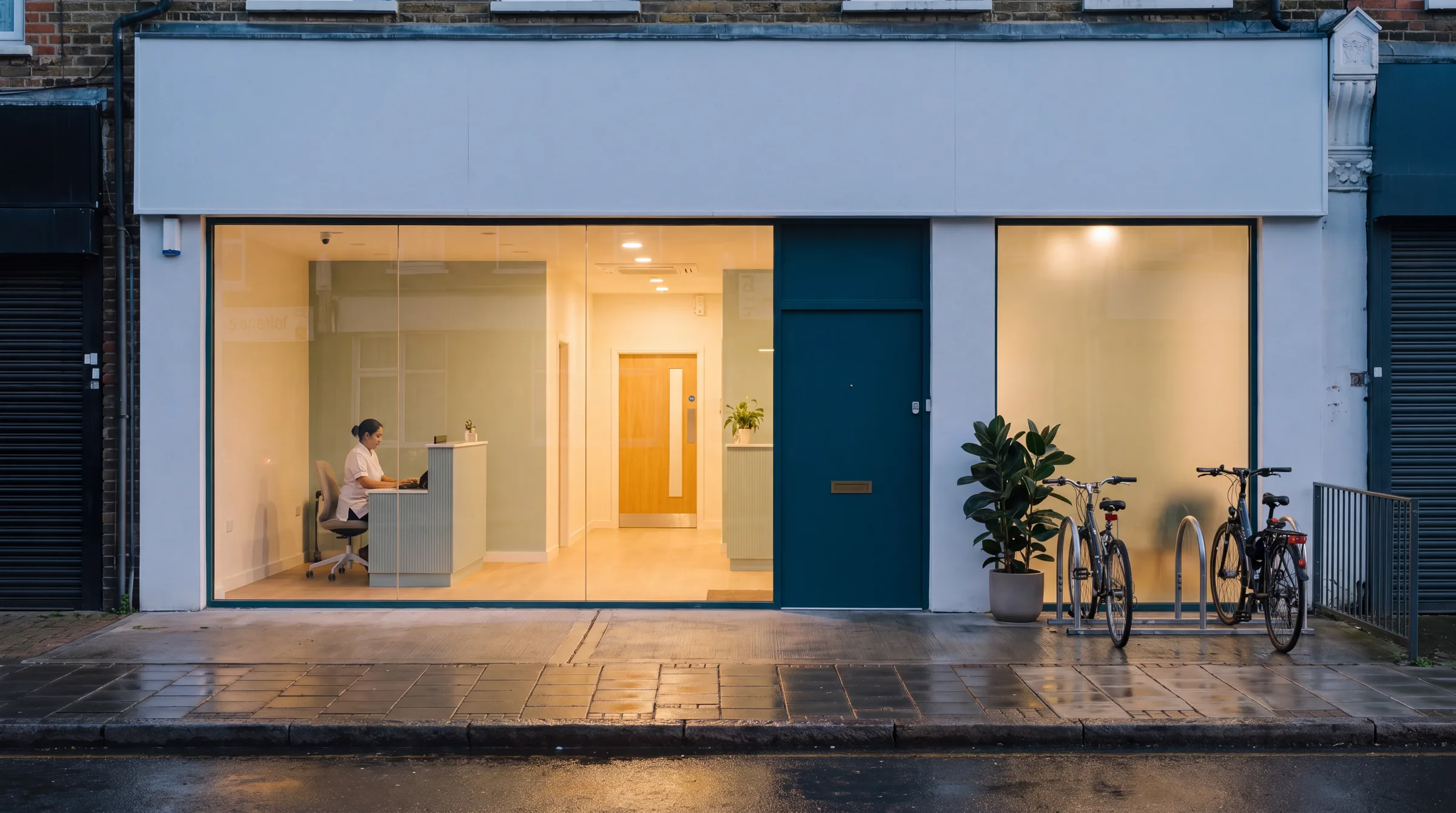 The glass-fronted Orford Road clinic glowing at dusk