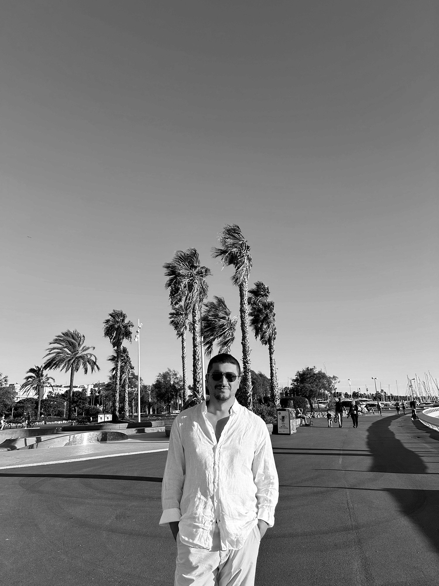 A thoughtful young person with dark hair gazes to the side, captured in soft black and white lighting.