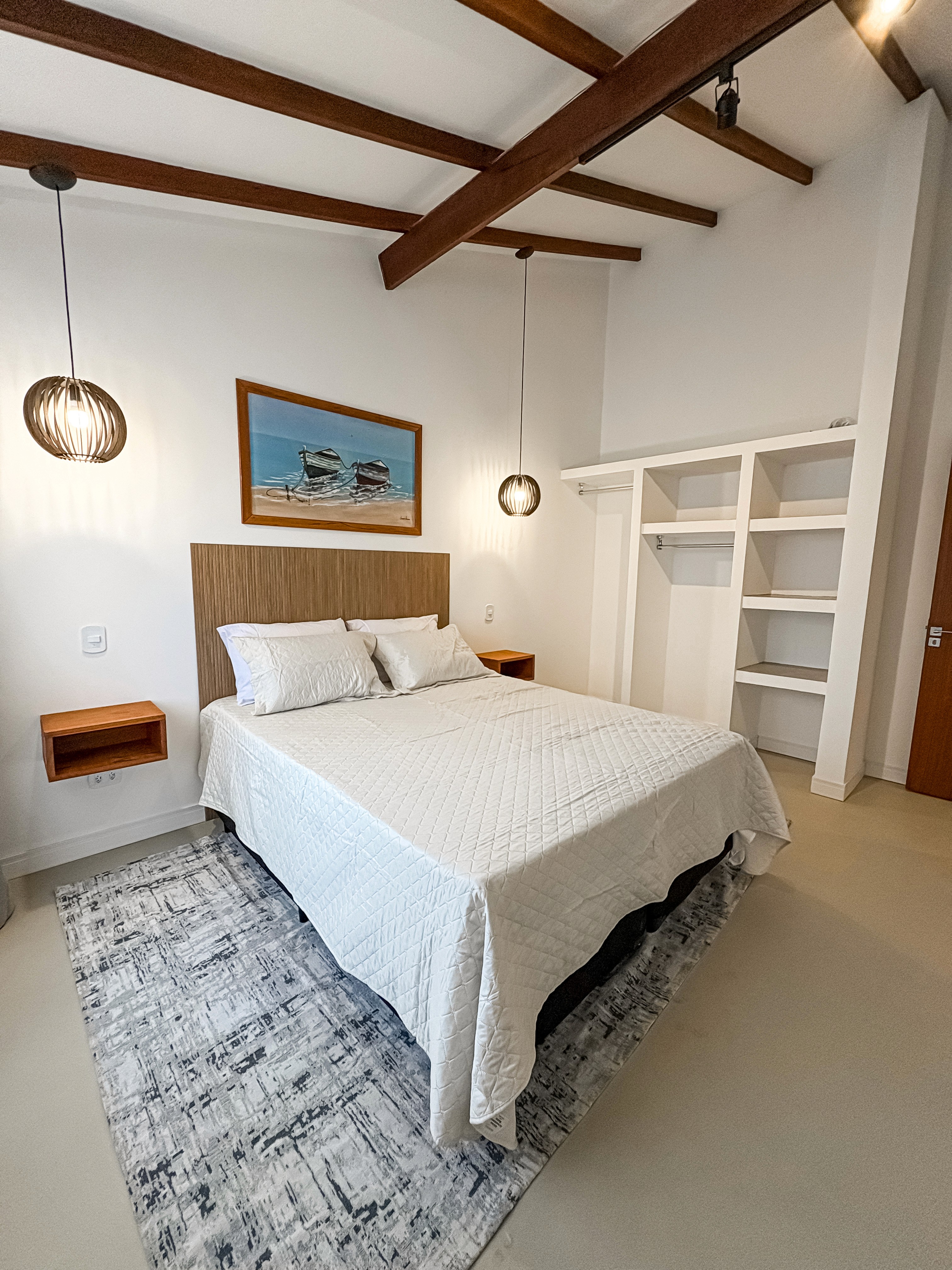 the elevated sleeping area with warm bedding, soft lighting, minimalist stairs, and smooth wood finishes.