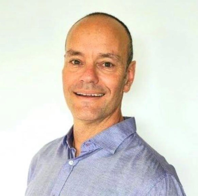 a portrait photo of ted ries dressed in a blue shirt