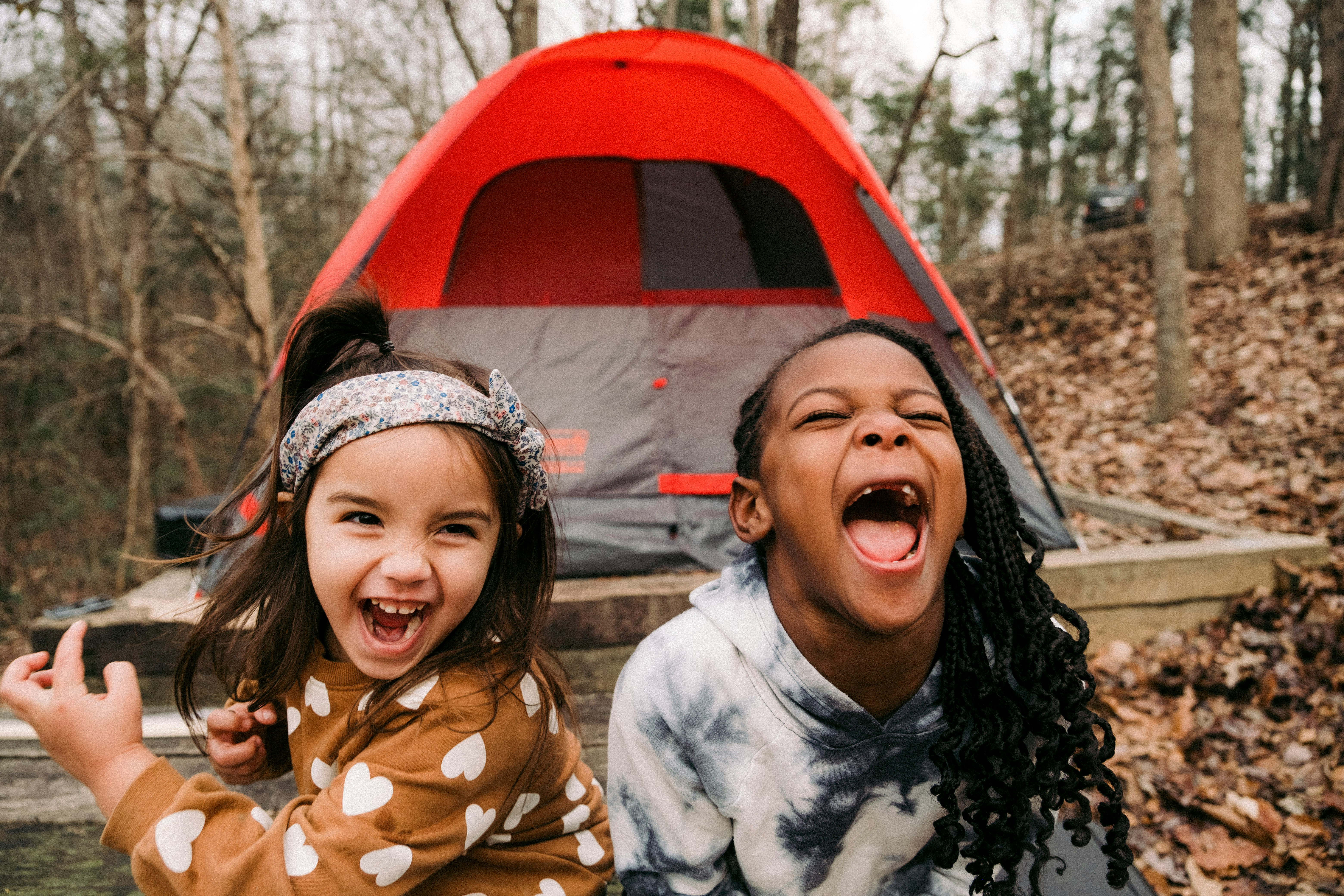 2 enfants devant une tente qui sourient