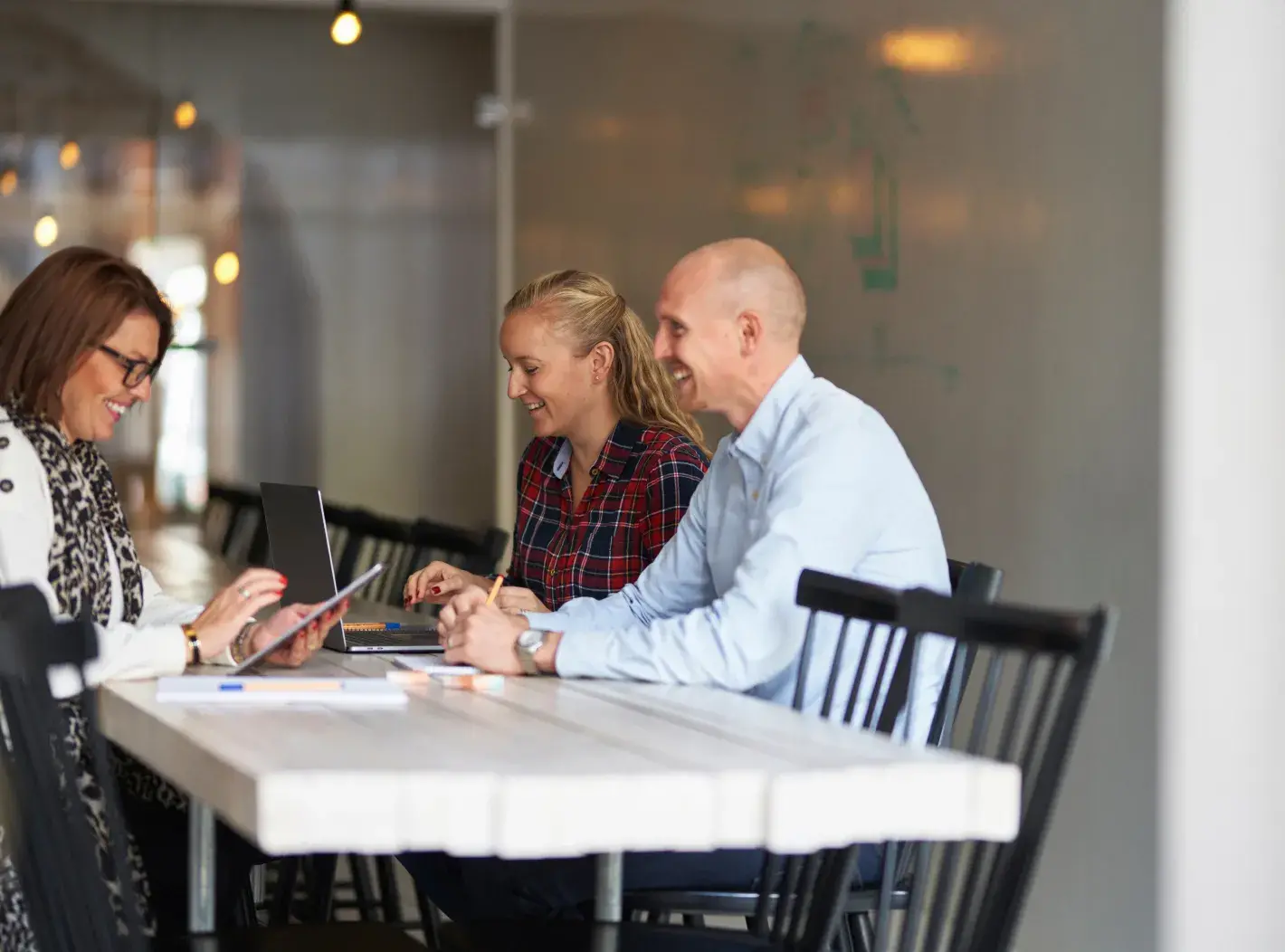 Réunion collaborative dans un groupe de cabinets comptables, avec des professionnels travaillant ensemble autour d'une table.