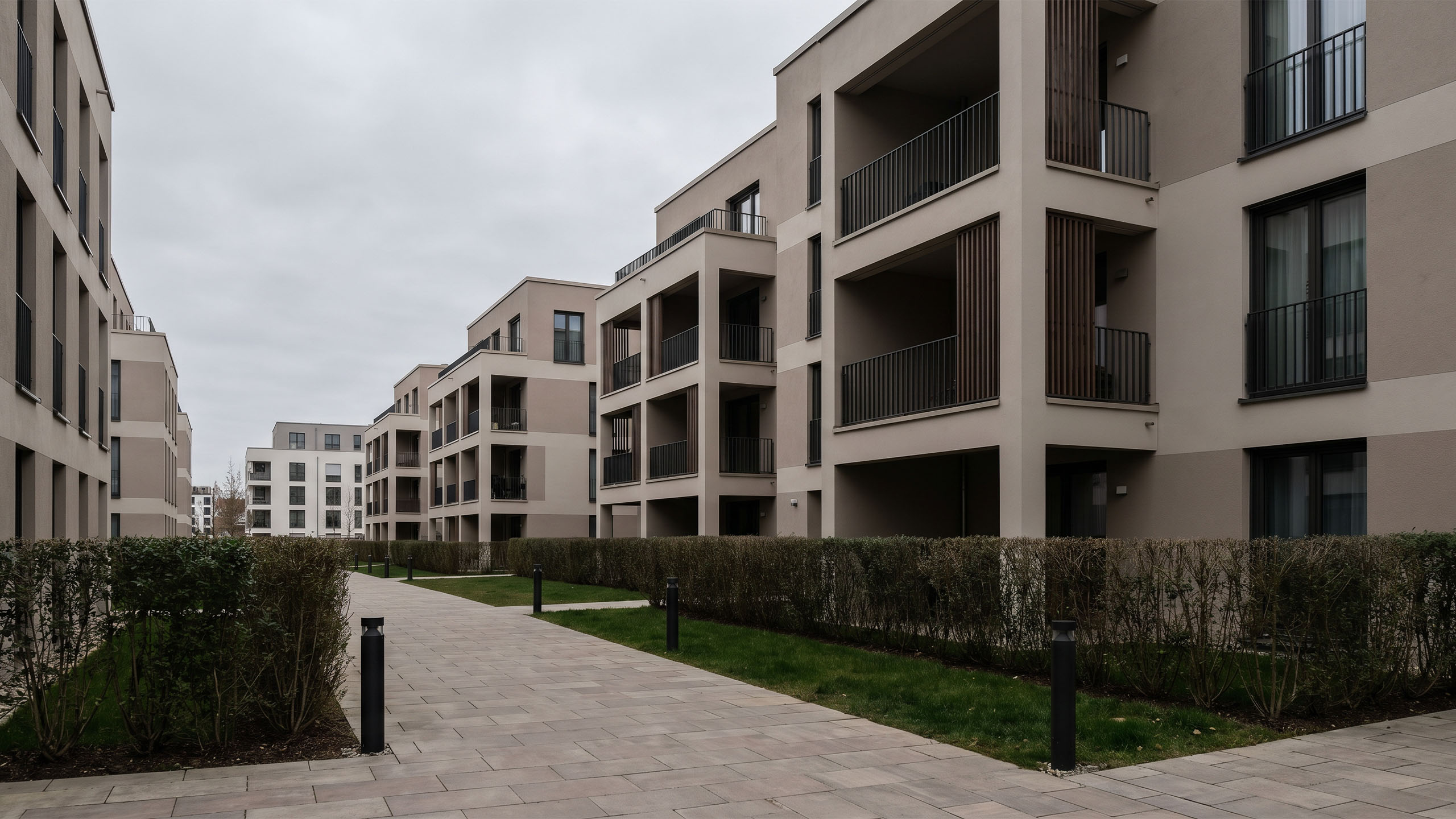Neubau-Wohnanlage mit Balkonen und begrüntem Innenhof
